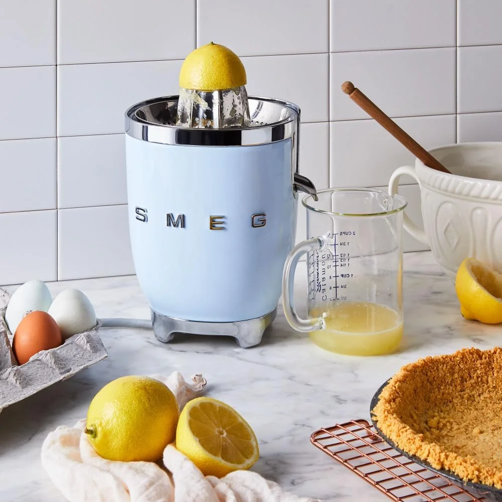 آب مرکبات گیری Smeg CJF11PBUK، طراحی استایل رترو دهه 50، دارای کاسه آبگیری و درب، خروجی ضد چکه استیل ضد زنگ، بدنه آلومینیومی دایکاست، آبی پاستلی، 1 سال گارانتی