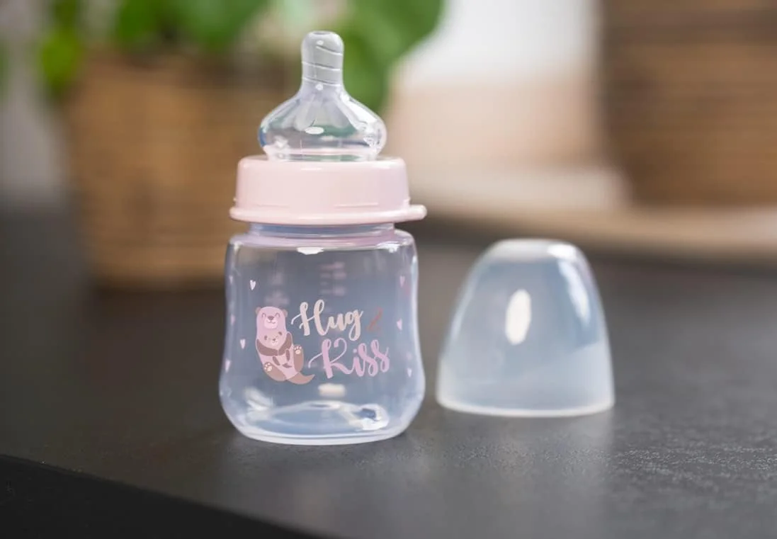 بطری شیرخوری دهانه گشاد نیپ، سرشیشه گرد سایز S، ساخته شده از سیلیکون، دارای دریچه ضد نفخ یکپارچه، 150 میلی لیتر، طرح Hug & Kiss صورتی بطری شیرخوری دهانه گشاد نیپ، سرشیشه گرد سایز S، ساخته شده از سیلیکون، دارای دریچه ضد نفخ یکپارچه، 150 میلی لیتر، طرح Hug & Kiss صورتی