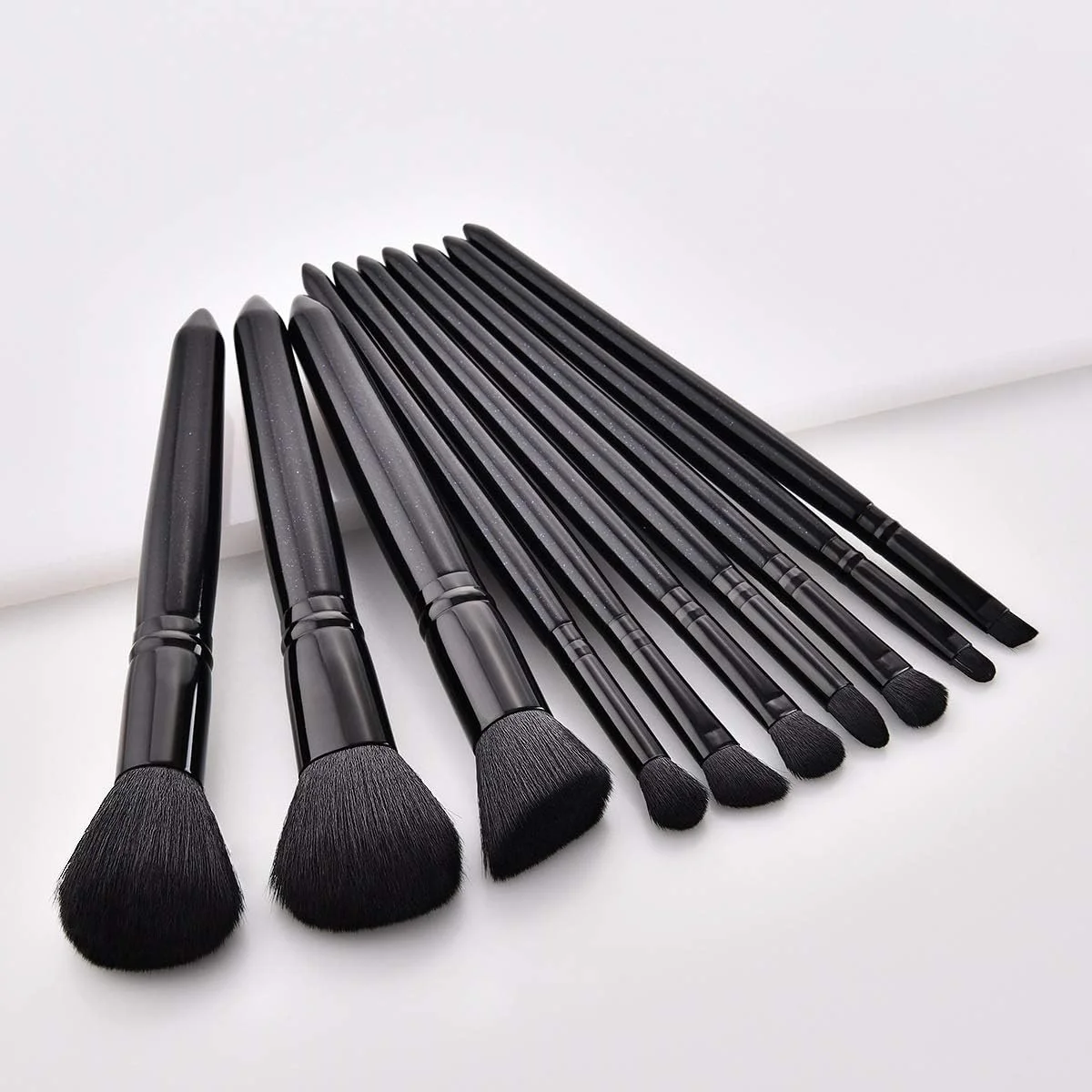 مجموعه برس آرایشی جینلیپ شامل 10 برس، برس کرم پودر، برس رژگونه، برس سایه چشم، برس هایلایتر و برس براق کننده لب - مشکی