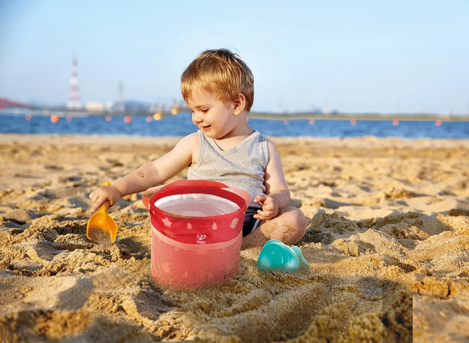 ست ساحلی تاشو Hape | کیف برزنتی تاشو با سطل ضد آب، قالب ماهی و بیلچه | ست اسباب بازی سبک وزن شن و آب برای تفریح در فضای باز | اسباب بازی های ساحلی | بادوام، بدون BPA | مناسب برای 18 ماه به بالا