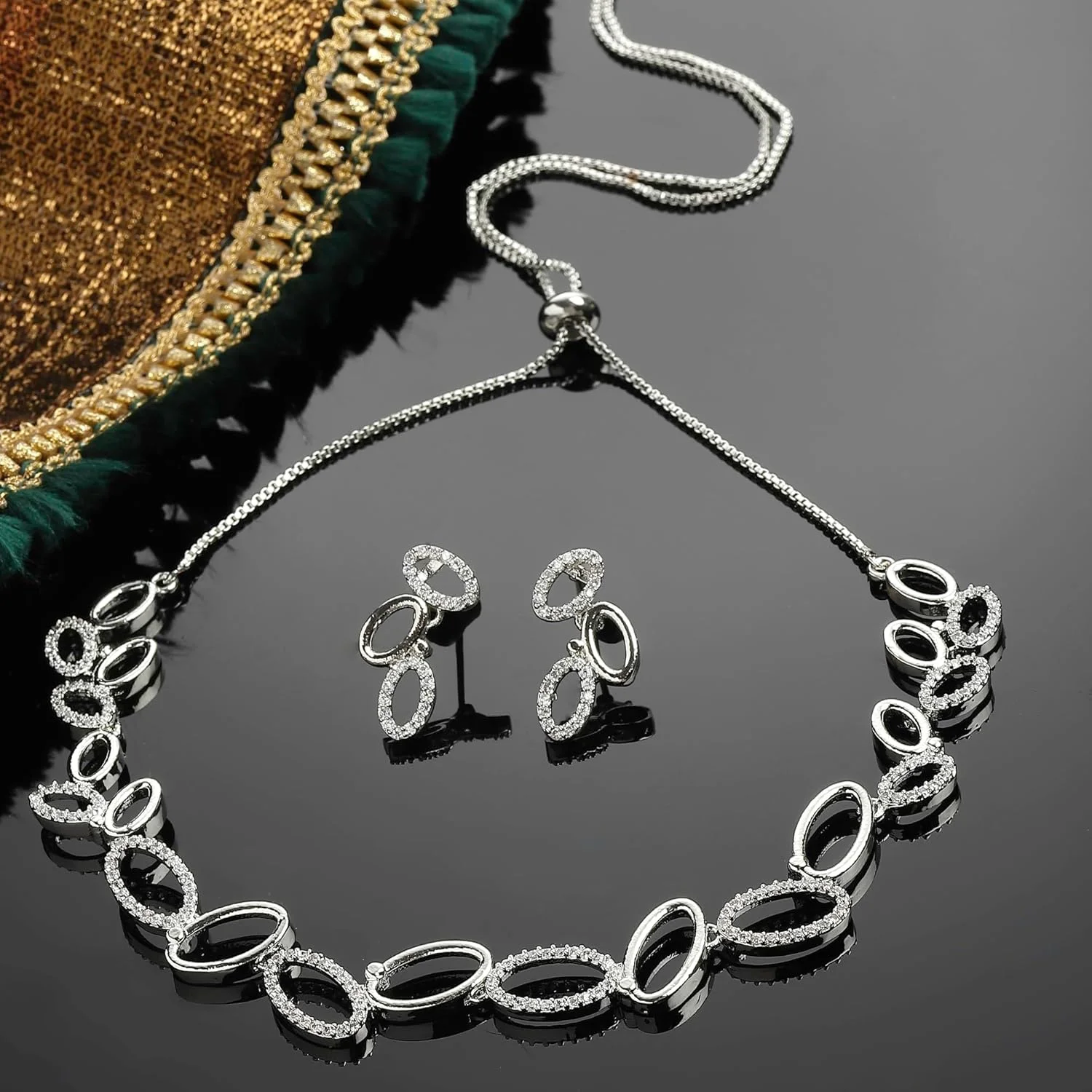 ست زیورآلات زنانه شامل گردنبند بیضی شکل نگین دار با الماس آمریکایی سفید و روکش طلا به همراه گوشواره برند زنمی ست زیورآلات زنانه شامل گردنبند بیضی شکل نگین دار با الماس آمریکایی سفید و روکش طلا به همراه گوشواره برند زنمی