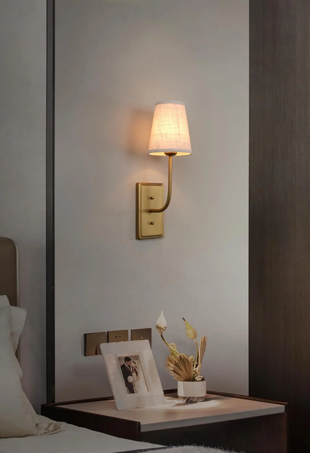 چراغ دیواری تک شاخه پرمو، روشنایی دیواری با سبک روستیک و وینتیج، دارای سایه بان پارچه ای قیفی شکل، مناسب برای دکور اتاق خواب، کنار تخت و مطالعه، پایه برنجی (کتان)