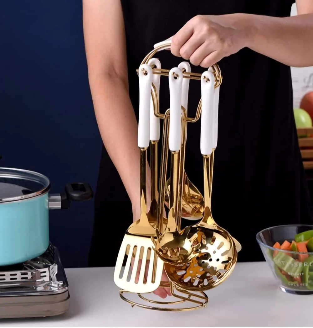 ست هفت پارچه لوازم آشپزخانه استیل آکواکس (طلایی سفید). شامل ۷ تکه ابزار آشپزی به همراه قفسه آویز. شامل کفگیر بزرگ، ملاقه سوپ، کاردک، قاشق پاستا.