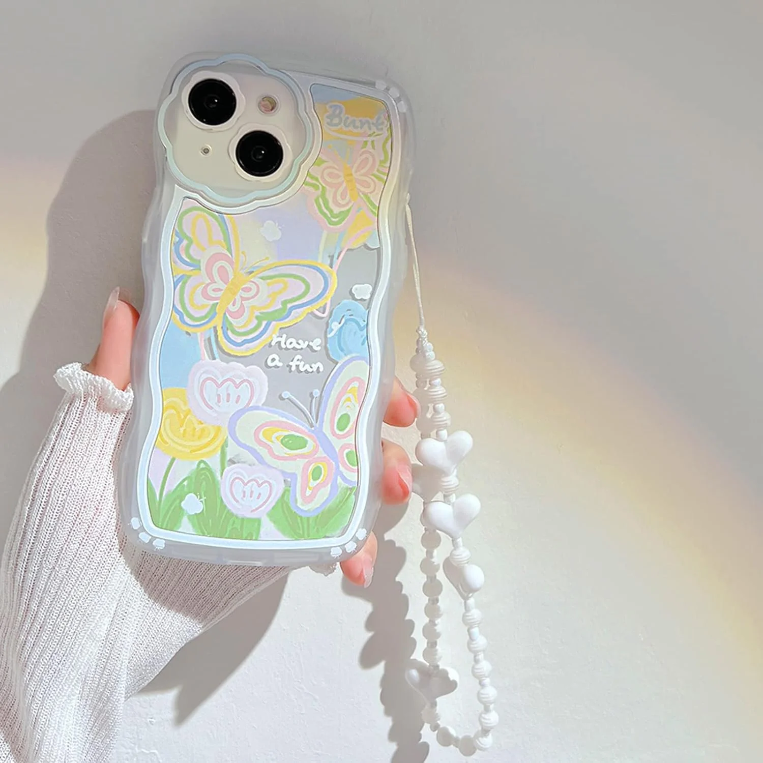 کاور محافظ آیفون 14 با طرح پروانه و گل کارتونی زیبا به همراه بند مچی مهره دار قلبی، جنس TPU نرم و محافظ کامل - طرح پروانه