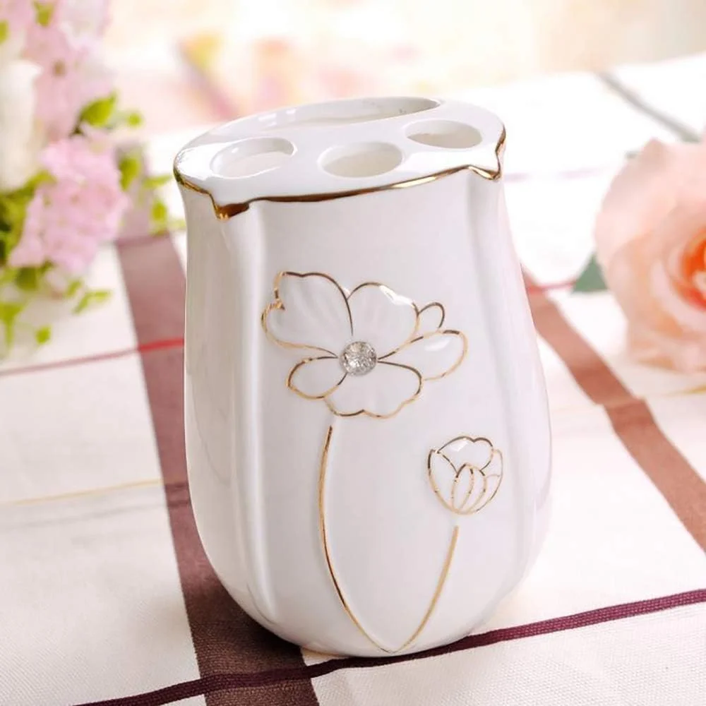 ست لوازم جانبی سرامیکی حمام 5 تکه طرح گلدار با نوار طلایی شامل جا مایع لوسیون، جا مسواکی، 2 عدد لیوان و جا صابونی ست لوازم جانبی سرامیکی حمام 5 تکه طرح گلدار با نوار طلایی شامل جا مایع لوسیون، جا مسواکی، 2 عدد لیوان و جا صابونی