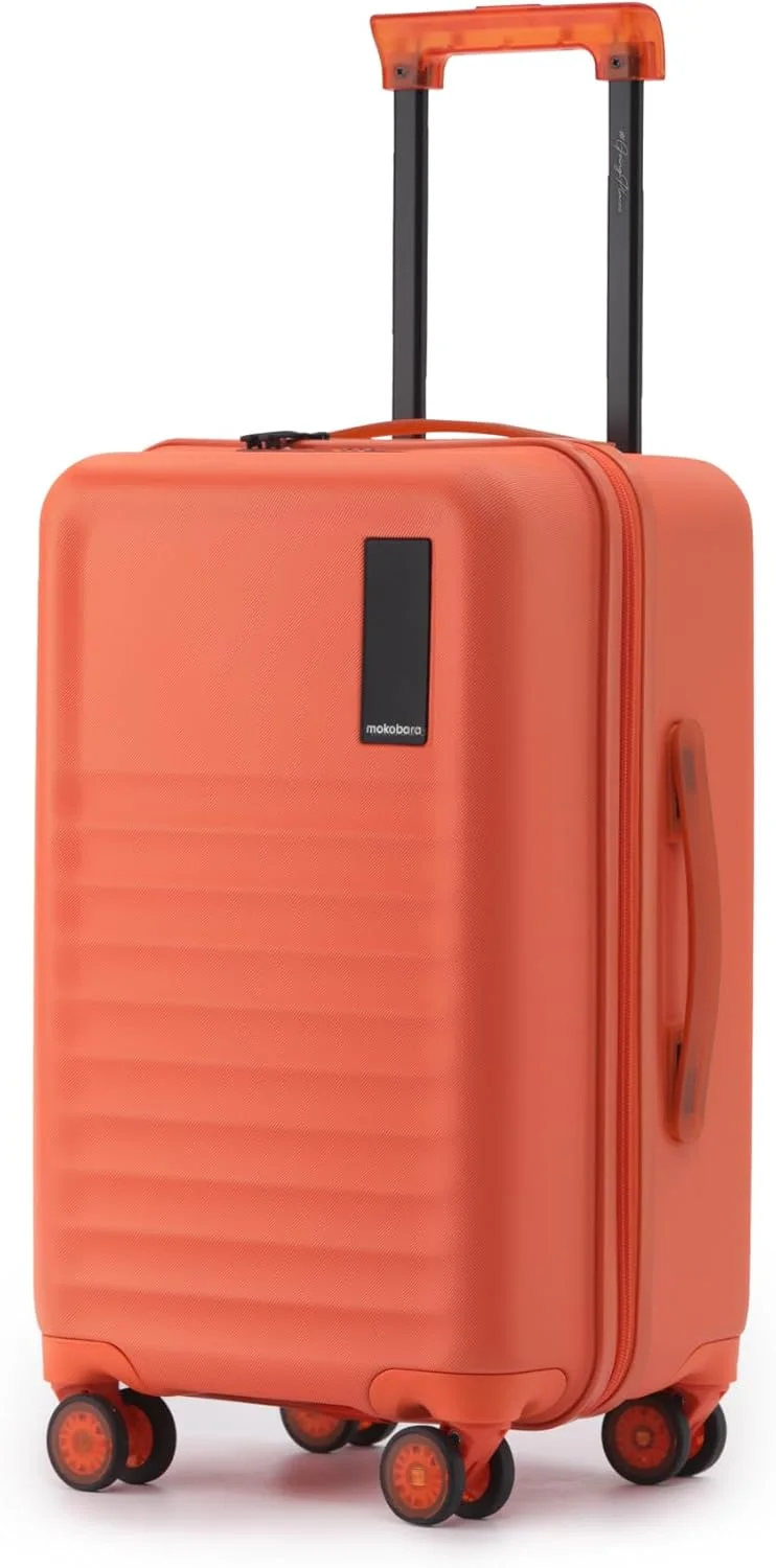 چمدان کابین Mokobara The Aisle Trunk | بدنه پلی کربنات 56 سانتی‌متری، زیپ‌های YKK، قفل مورد تایید TSA و چرخ‌های نینجا بی‌صدا (کابین، استارداست) نارنجی