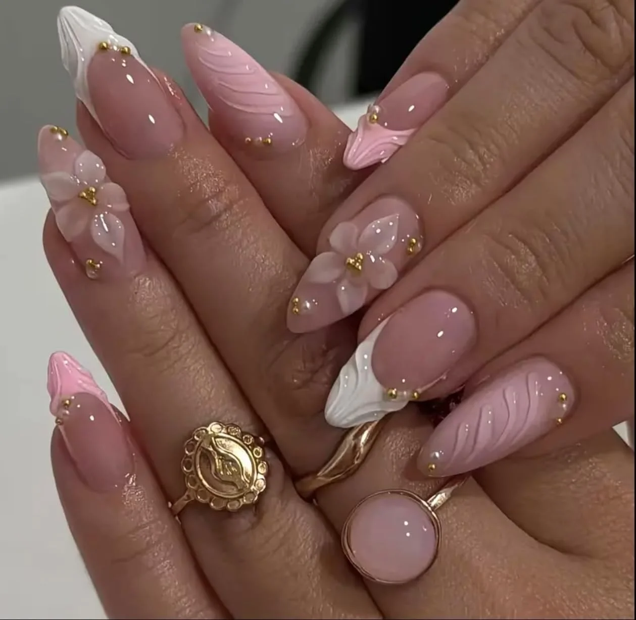 ناخن مصنوعی بادامی لوکس ۲۴ عددی + یک عدد چسب ۱۲ میلی لیتری و یک ورق چسب ژله ای، طراحی گل سه بعدی صورتی و سفید با مروارید طلایی، قد متوسط، پوشش کامل، روکش براق