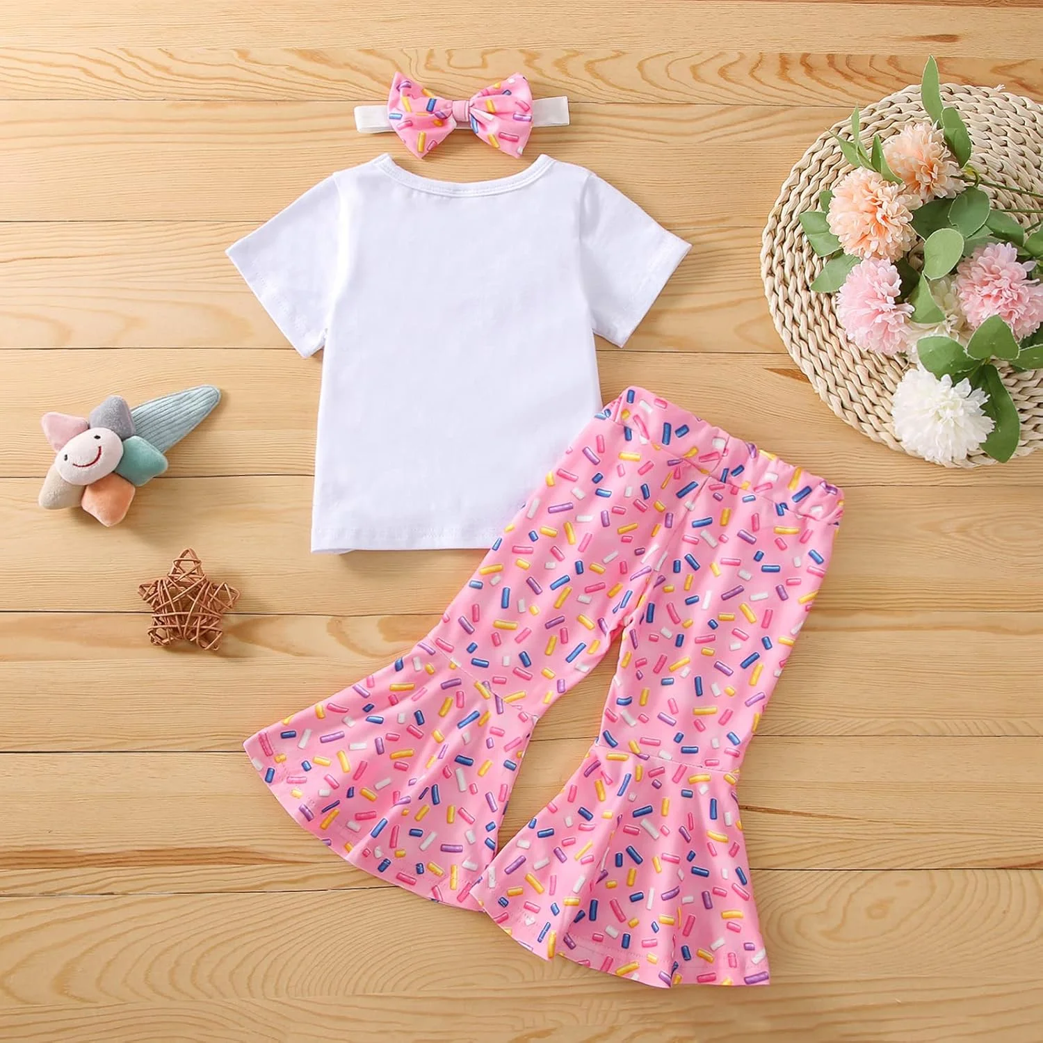 ست لباس تولد دخترانه شامل تیشرت آستین بلند، شلوار دمپا گشاد طرح دونات و هدبند