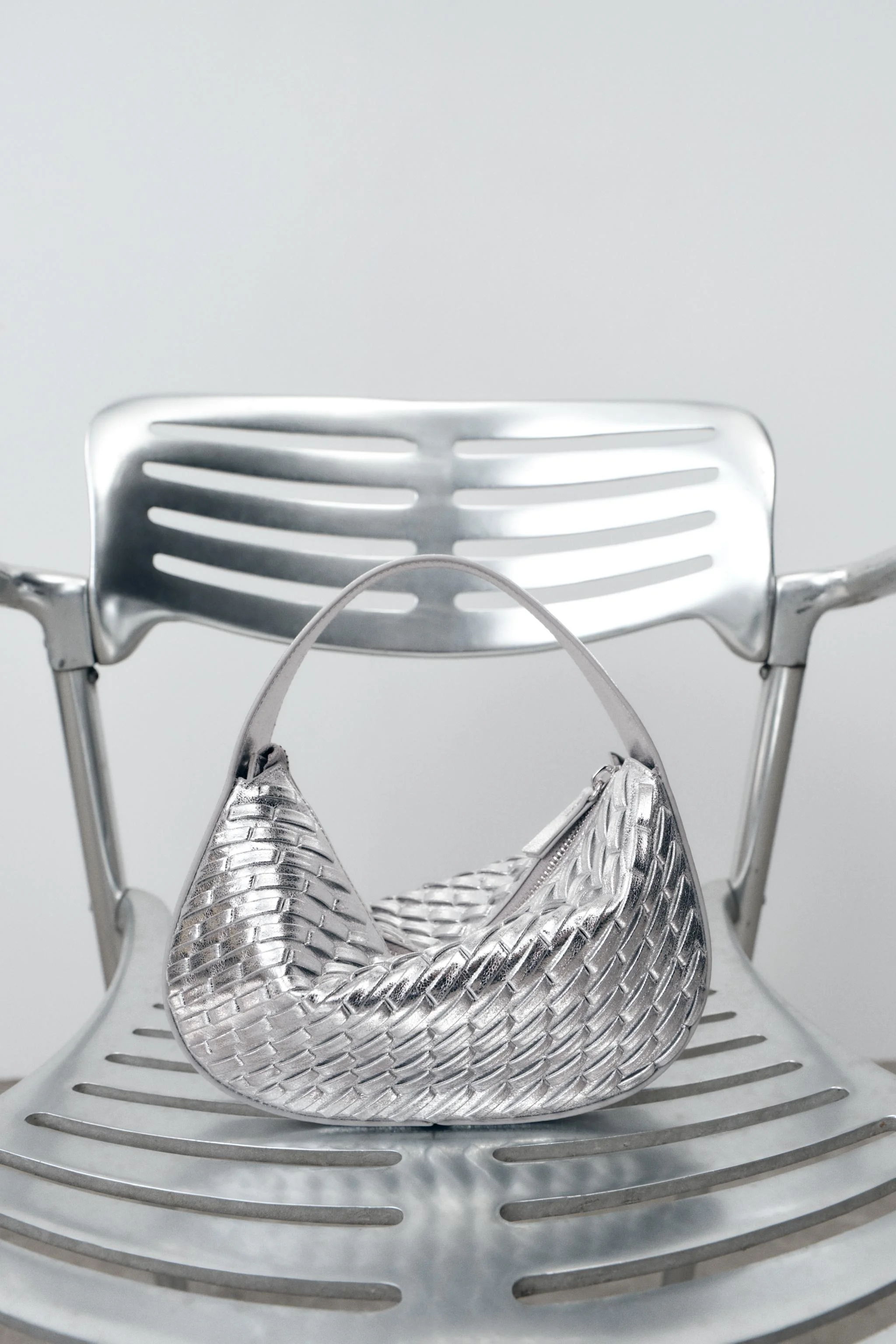 کیف دستی با بافت فلزی. دارای دسته پهن. بند دوشی جداشدنی. دارای زیپ فلزی. ابعاد: ۱۲x۲۰x۴ سانتی متر