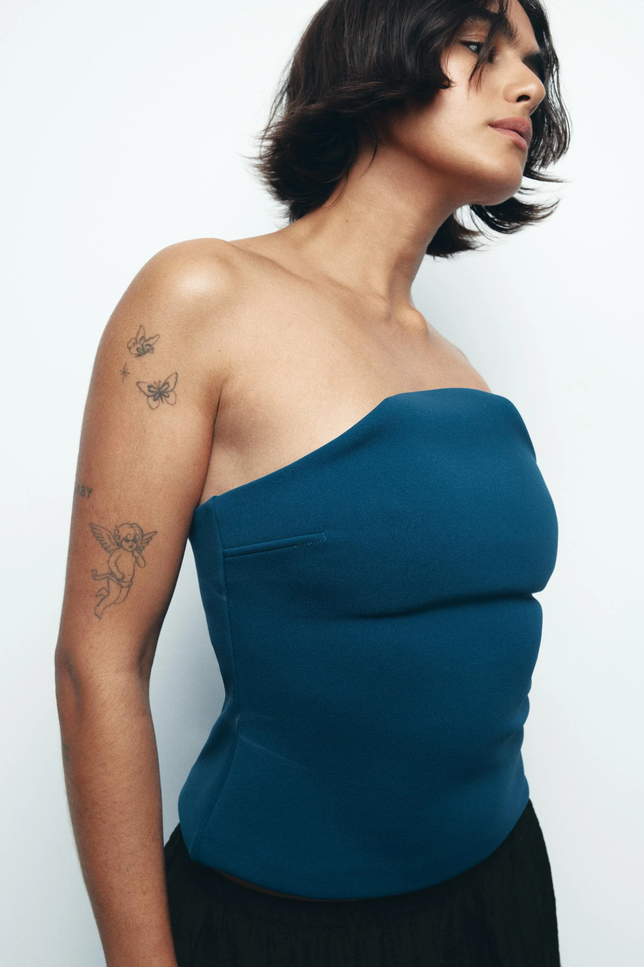 تاپ بدون بند با شانه های نمایان. دارای زیپ مخفی در پهلو. تاپ بدون بند با شانه های نمایان. دارای زیپ مخفی در پهلو.