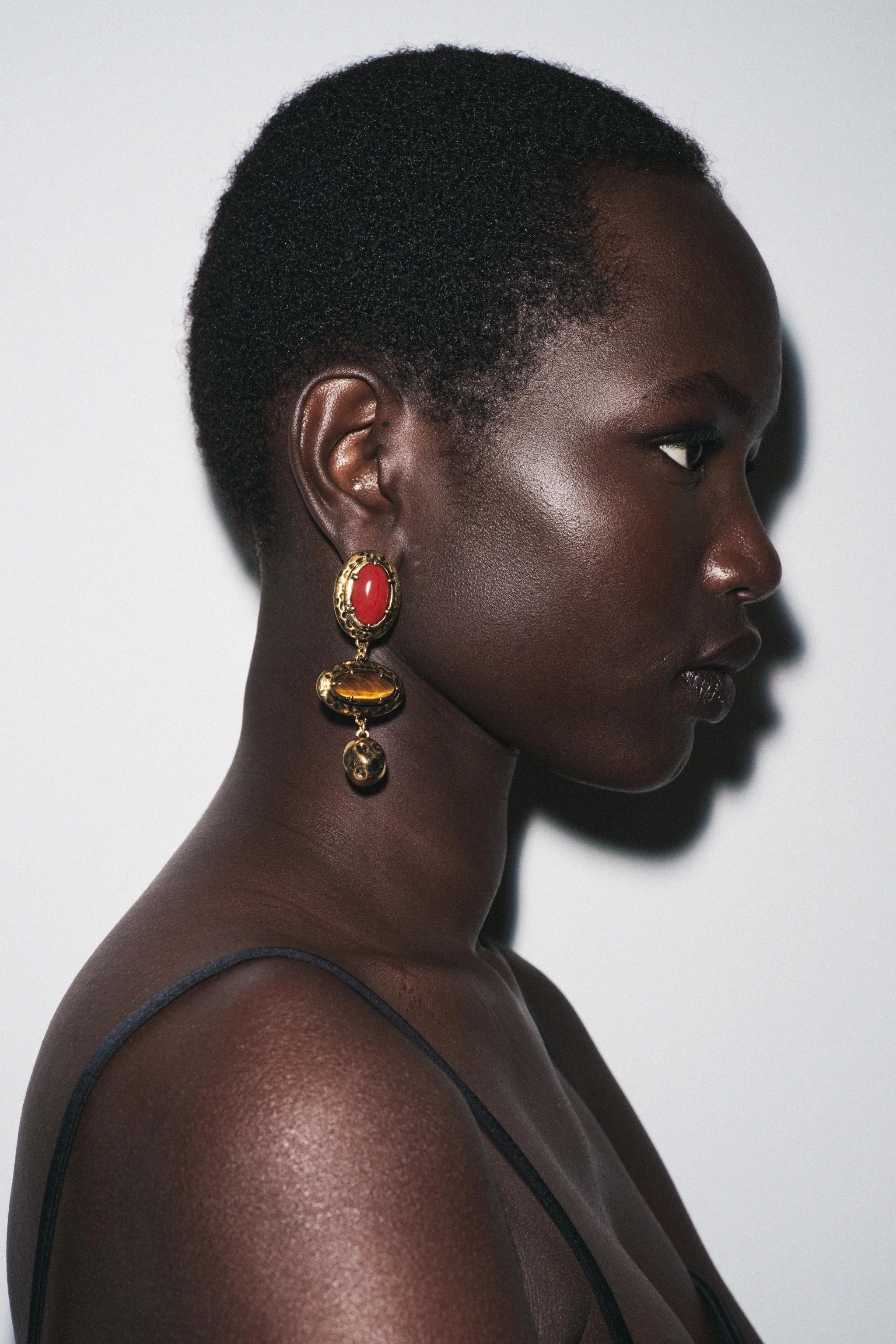 گوشواره های آویز فلزی بافت دار با جزئیات سنگ های رنگارنگ. دارای قفل پروانه ای.