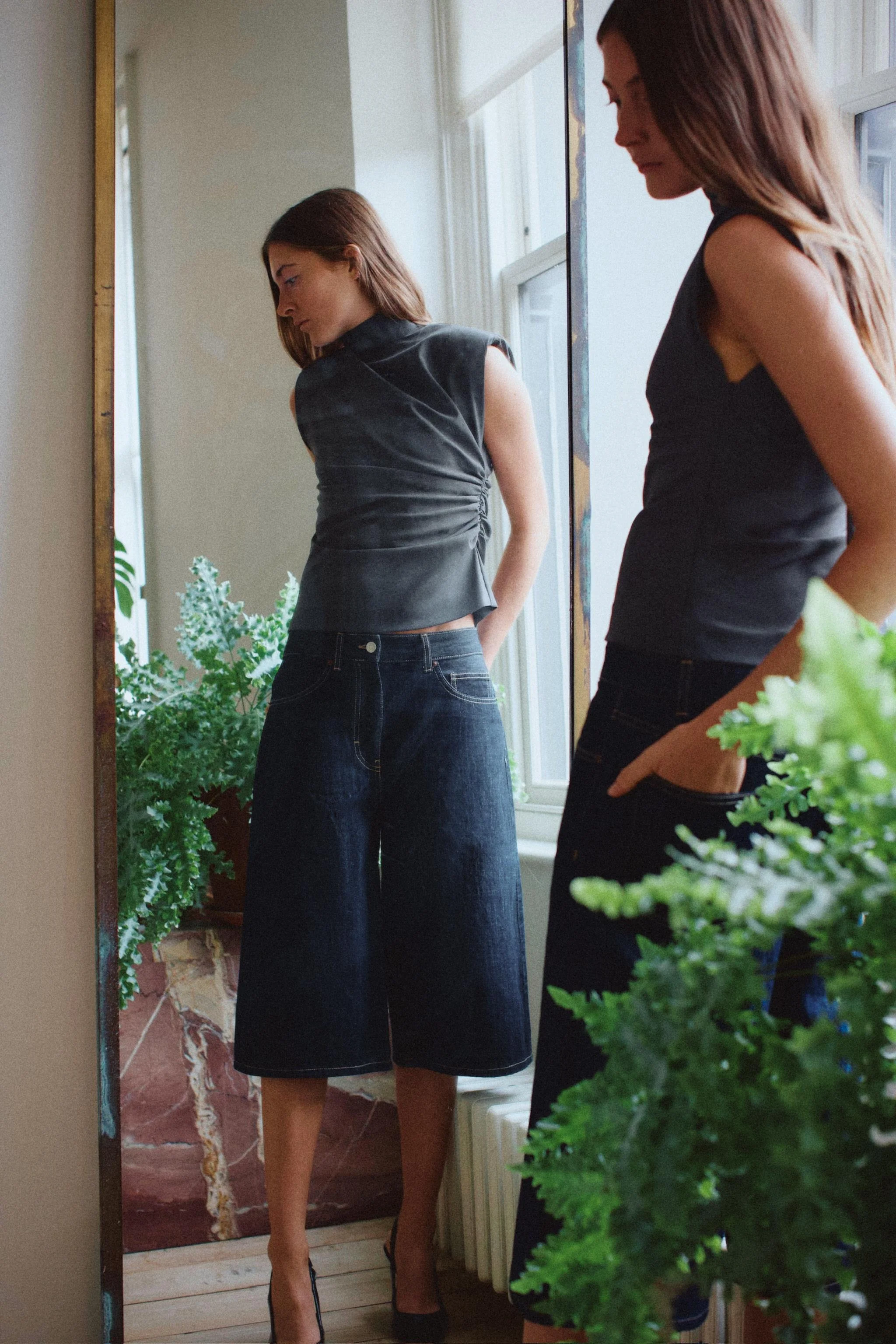 تاپ یقه ایستاده با بند. مدل آستین حلقه ای با پدهای سرشانه. دارای جزئیات چین دار در قسمت پهلو.