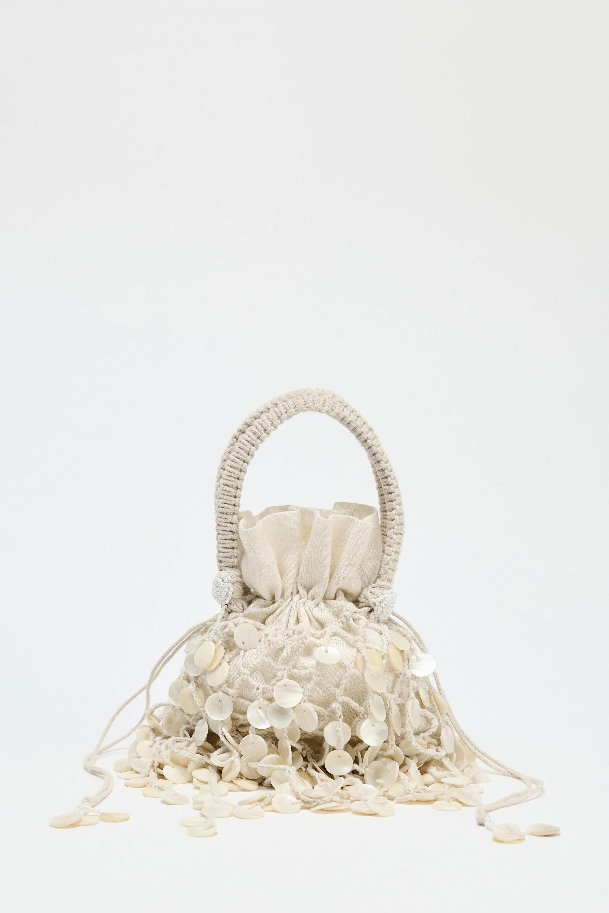 کیف دستی با تزیینات اپلیکه مرواریدی در قسمت بالایی. دارای دو دسته در قسمت بالا. دارای کیف داخلی با بند کشی. ارتفاع x طول x عرض: 12 x 15 x 7 سانتی متر / 4.7 x 5.9 x 2.7 اینچ