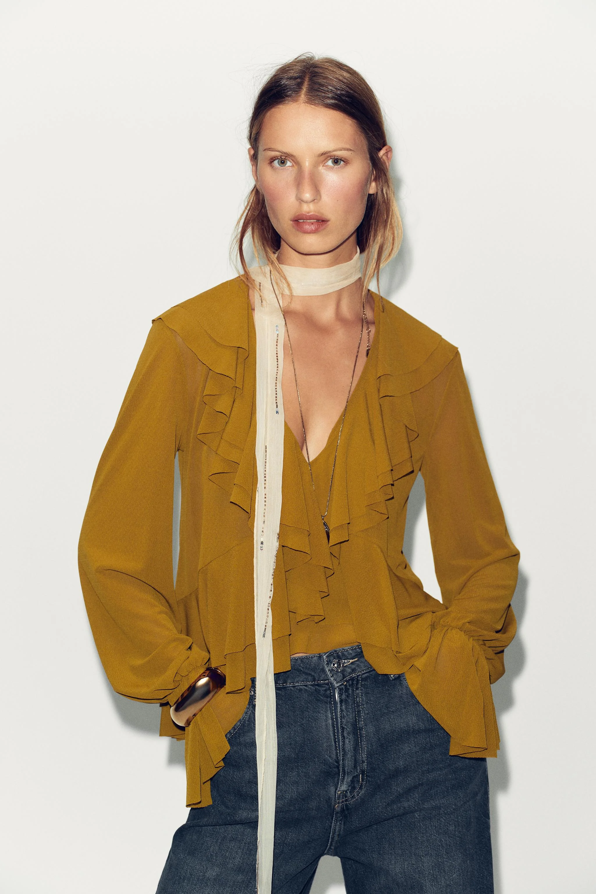 بلوز یقه هفت آستین بلند با سرآستین کشی و چین دار. دارای چین در قسمت جلوی لباس از جنس خود پارچه و لبه نامتقارن.