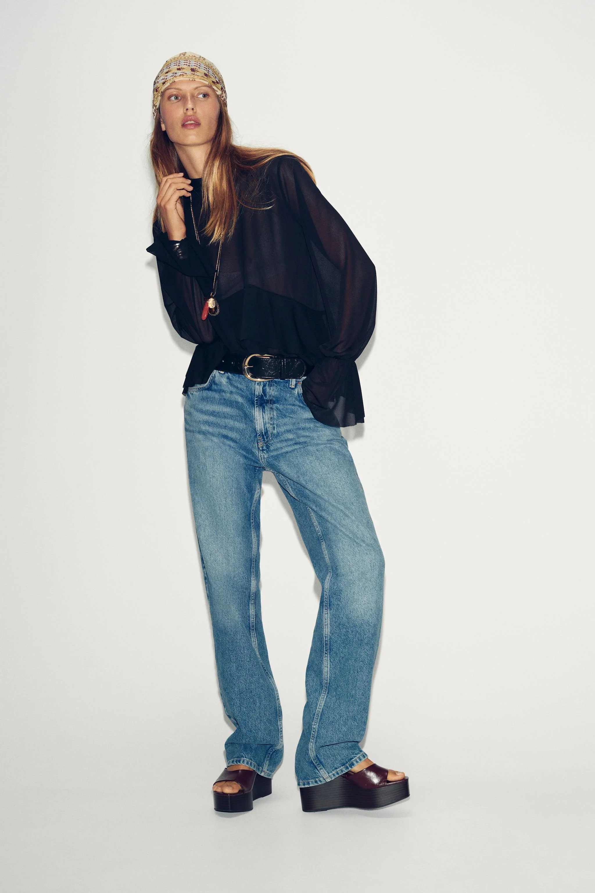 بلوز روان یقه گرد با بند قابل تنظیم در پشت. آستین بلند با سرآستین کشی و چین دار. لبه نامتقارن با چین هم جنس.