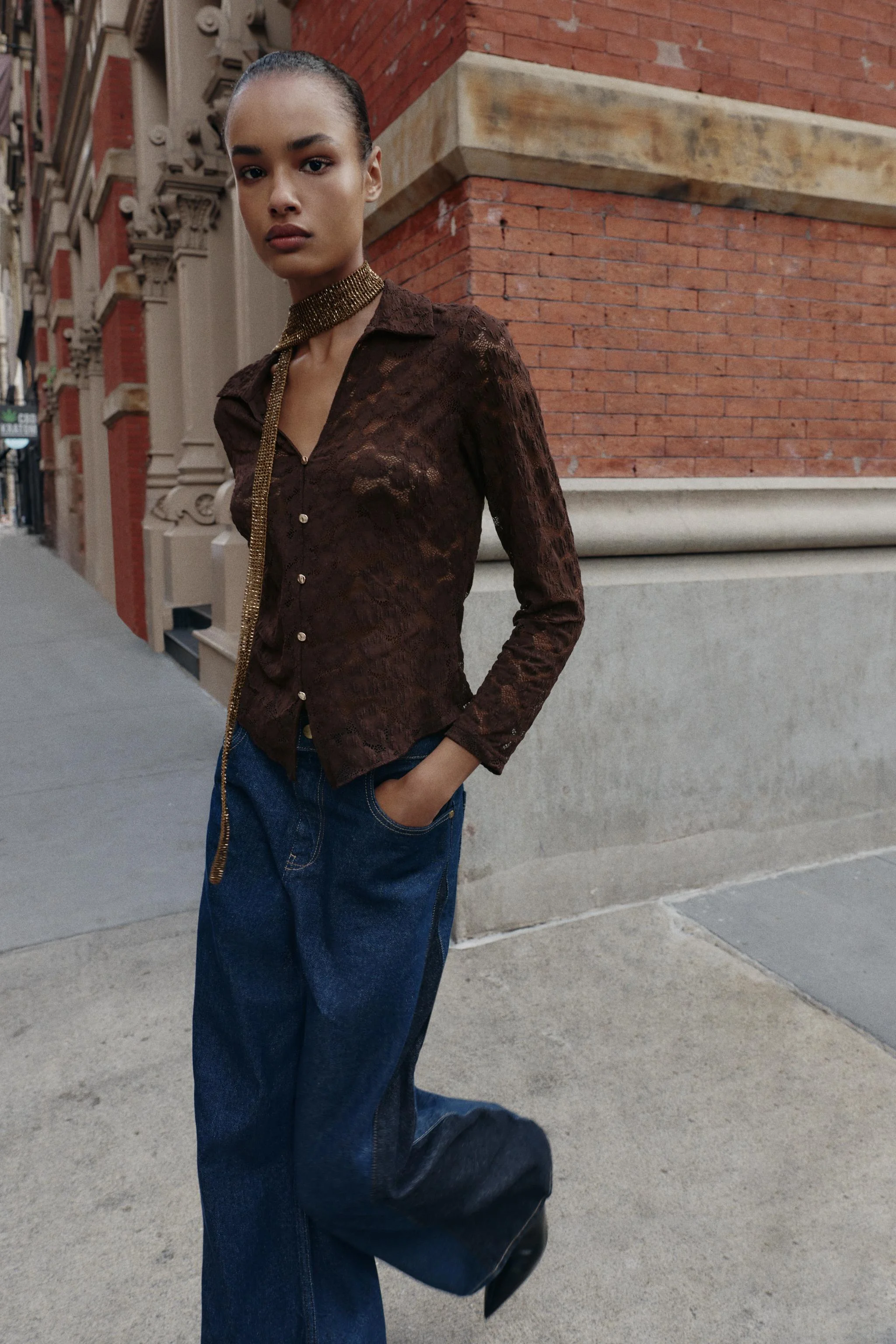 تاپ آستین بلند با یقه برگردان و یقه هفت. دارای دکمه های طلایی تزئینی در قسمت جلو.