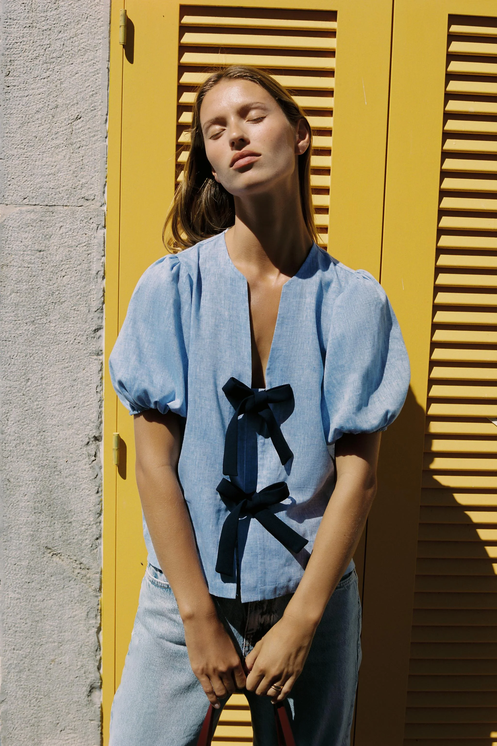 بلوز با ترکیب پارچه لینن. یقه گرد با برش هفت و آستین های کوتاه پفی با لبه کشی. دارای بند برای گره زدن در قسمت جلو.