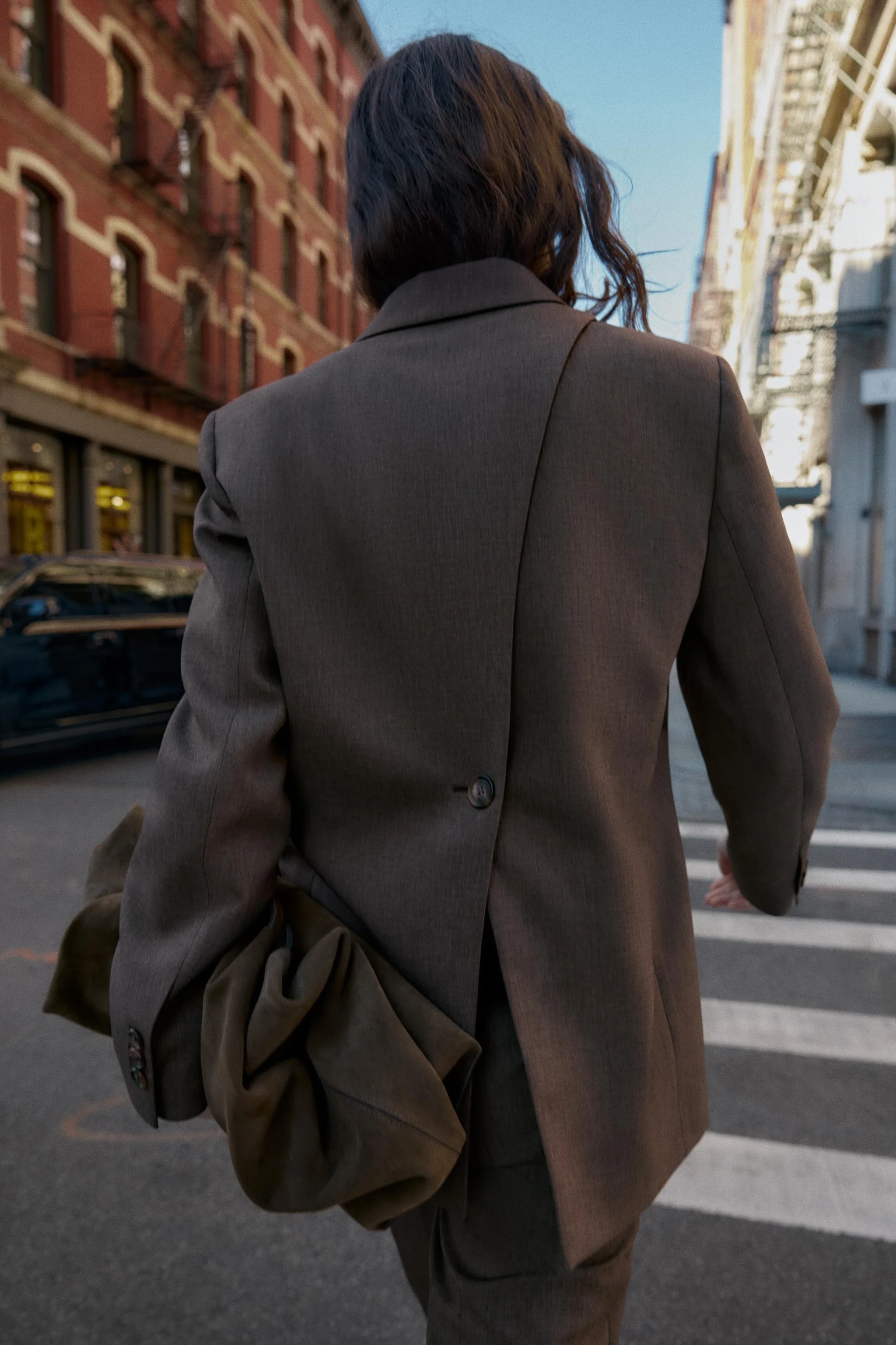 بلیزر یقه برگردان و آستین بلند با پد شانه. دارای جیب های پاکتی در جلو، سجاف با چاک پشتی دکمه دار و بست دکمه ای در جلو.