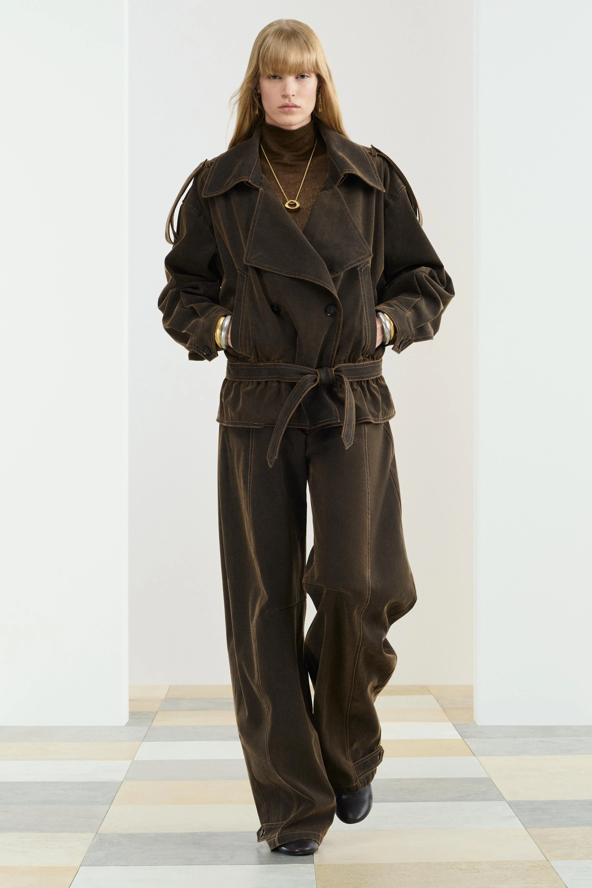 کت با یقه برگردان و آستین بلند. دارای جیب های جلویی. کمربند قابل تنظیم از جنس خود پارچه. دارای جزئیات دوخت تزئینی متضاد. بستن جلوی ضربدری با دکمه.