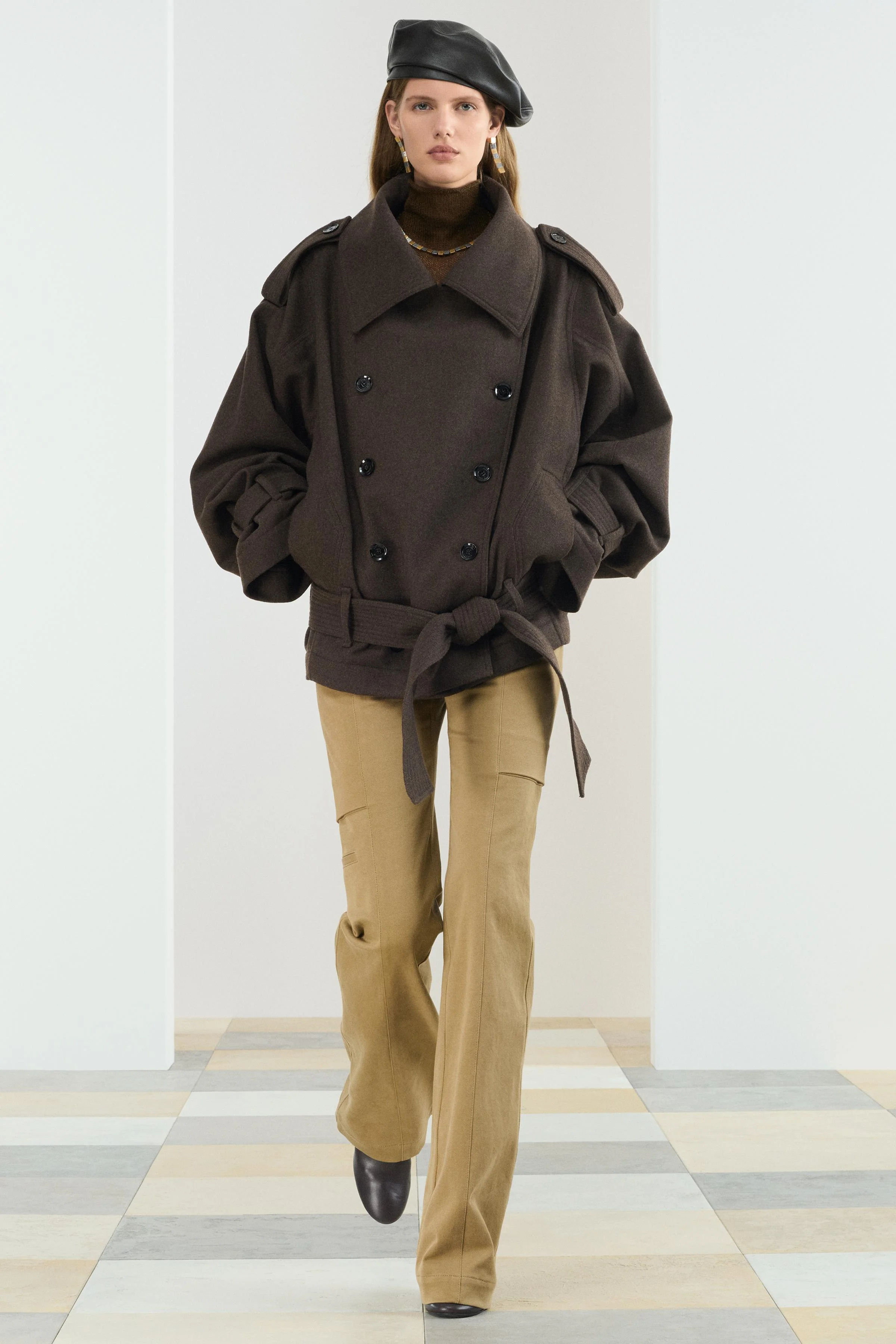 کت کوتاه بافته شده از 49% پشم. دارای یقه برگردان و آستین های بلند با حلقه. جیب های جلو. کمربند قابل تنظیم از جنس پارچه با گره. حلقه های سرشانه. بست دکمه ای در جلو.