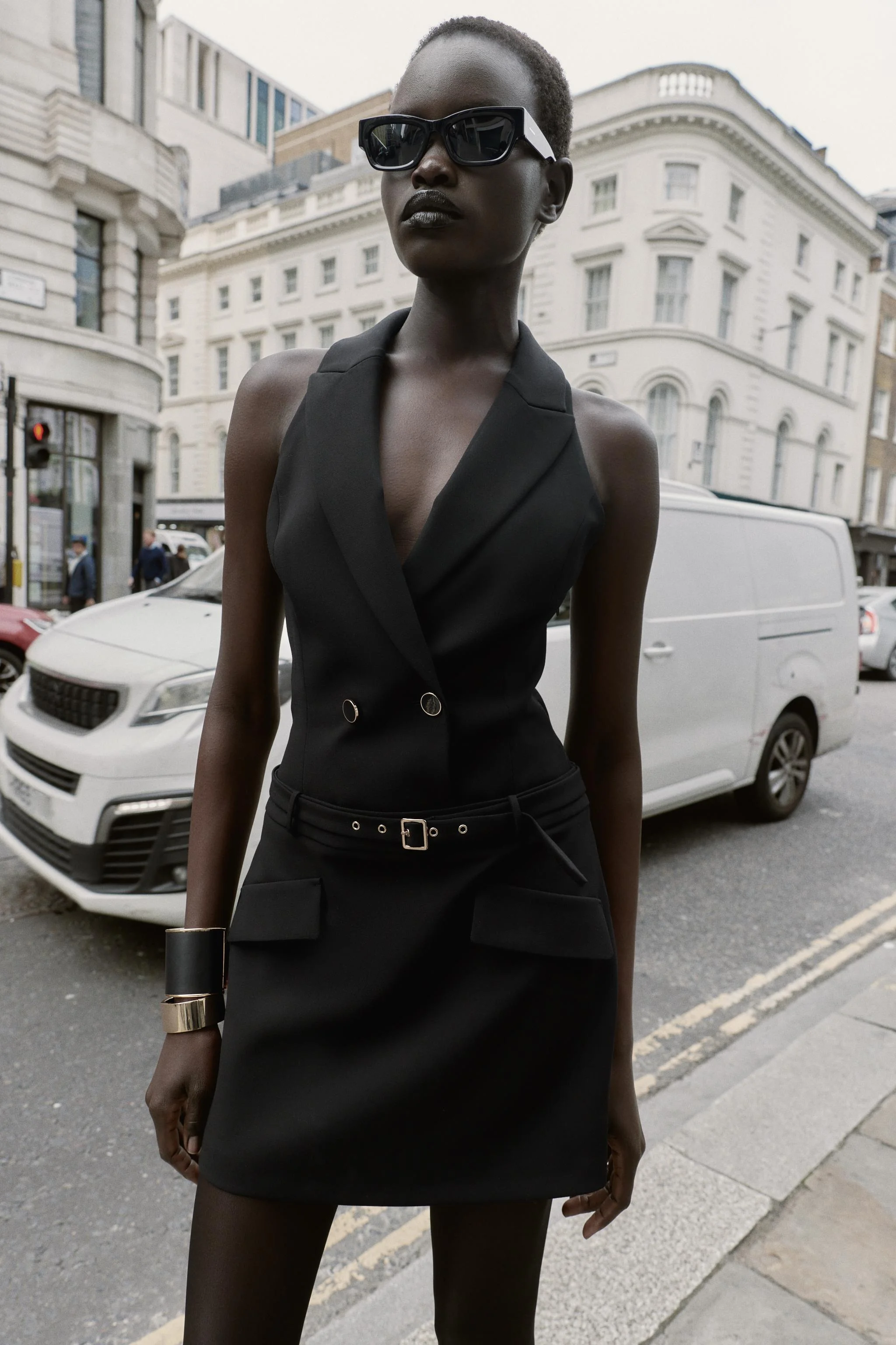 پیراهن کوتاه با مدل بلیزر، یقه هالتر، دارای کمربند و جیب های پاکتی در جلو. دارای دکمه در جلو و زیپ مخفی در پهلو.