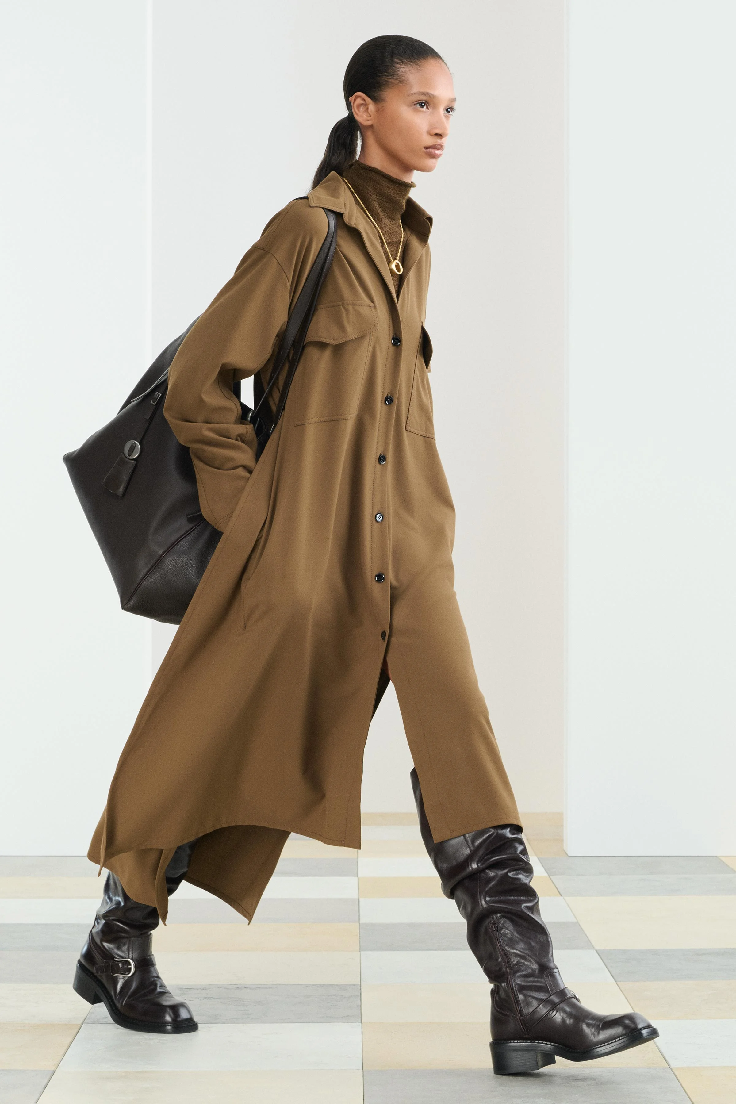 پیراهن میدی بافته شده از نخ پشمی ۲۱٪. دارای یقه برگردان و آستین های بلند با دکمه. جیب های پاکتی با سرجیب روی سینه. لبه دامن نامتقارن. دارای دکمه در قسمت جلوی پیراهن.