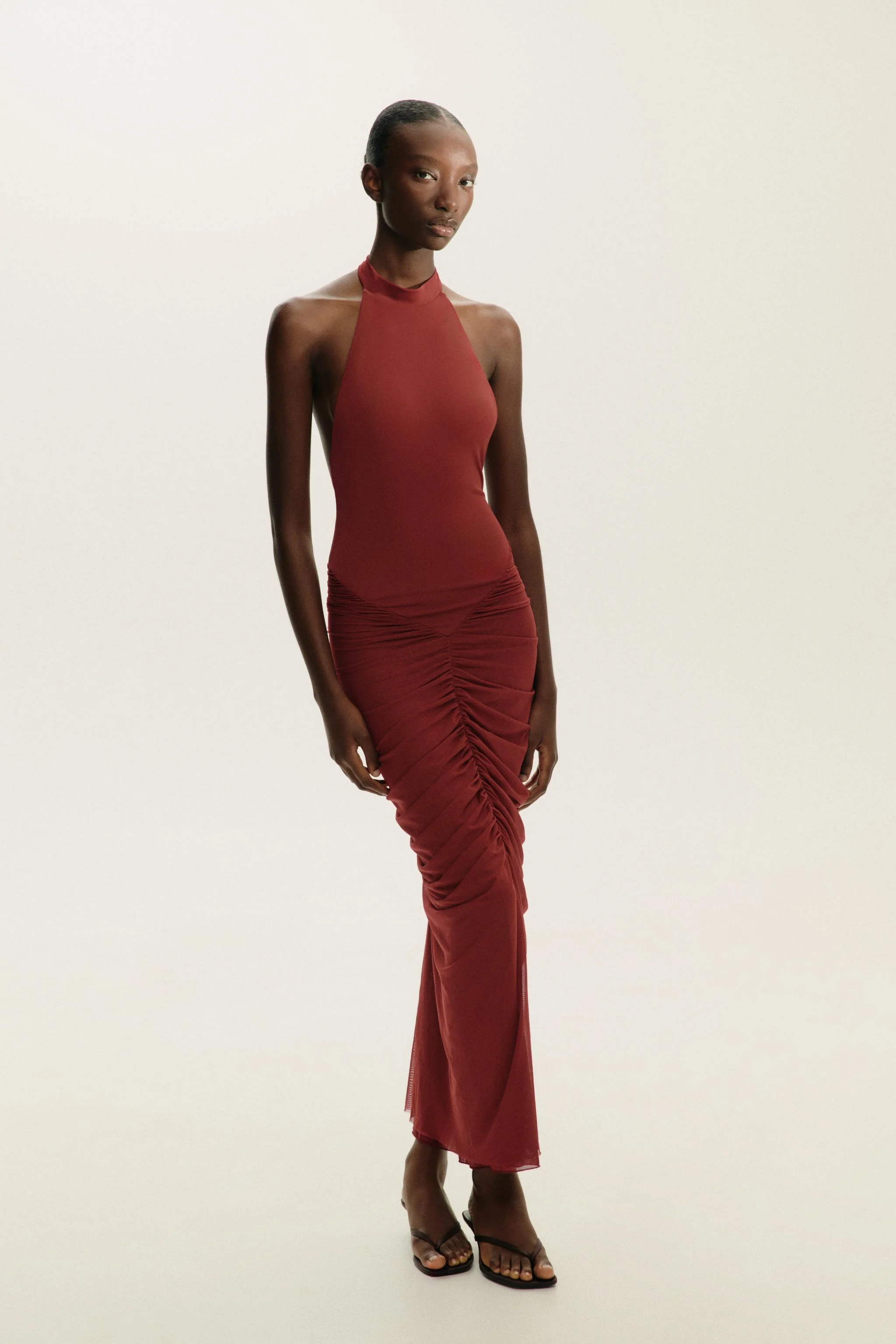 پیراهن بلند یقه هالتر با پارچه توری متضاد. دارای جزئیات جمع شده و دکمه بست در گردن.