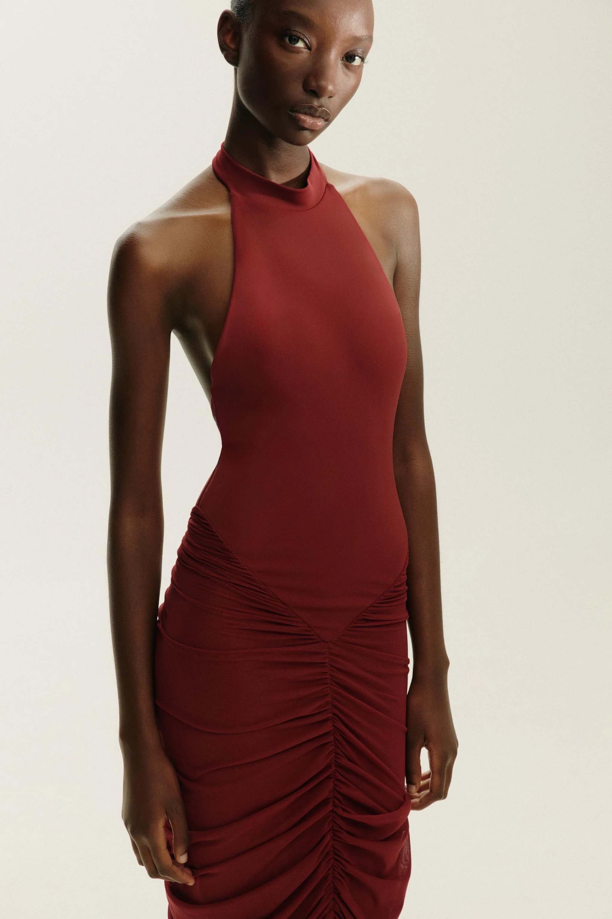 پیراهن بلند یقه هالتر با پارچه توری متضاد. دارای جزئیات جمع شده و دکمه بست در گردن.