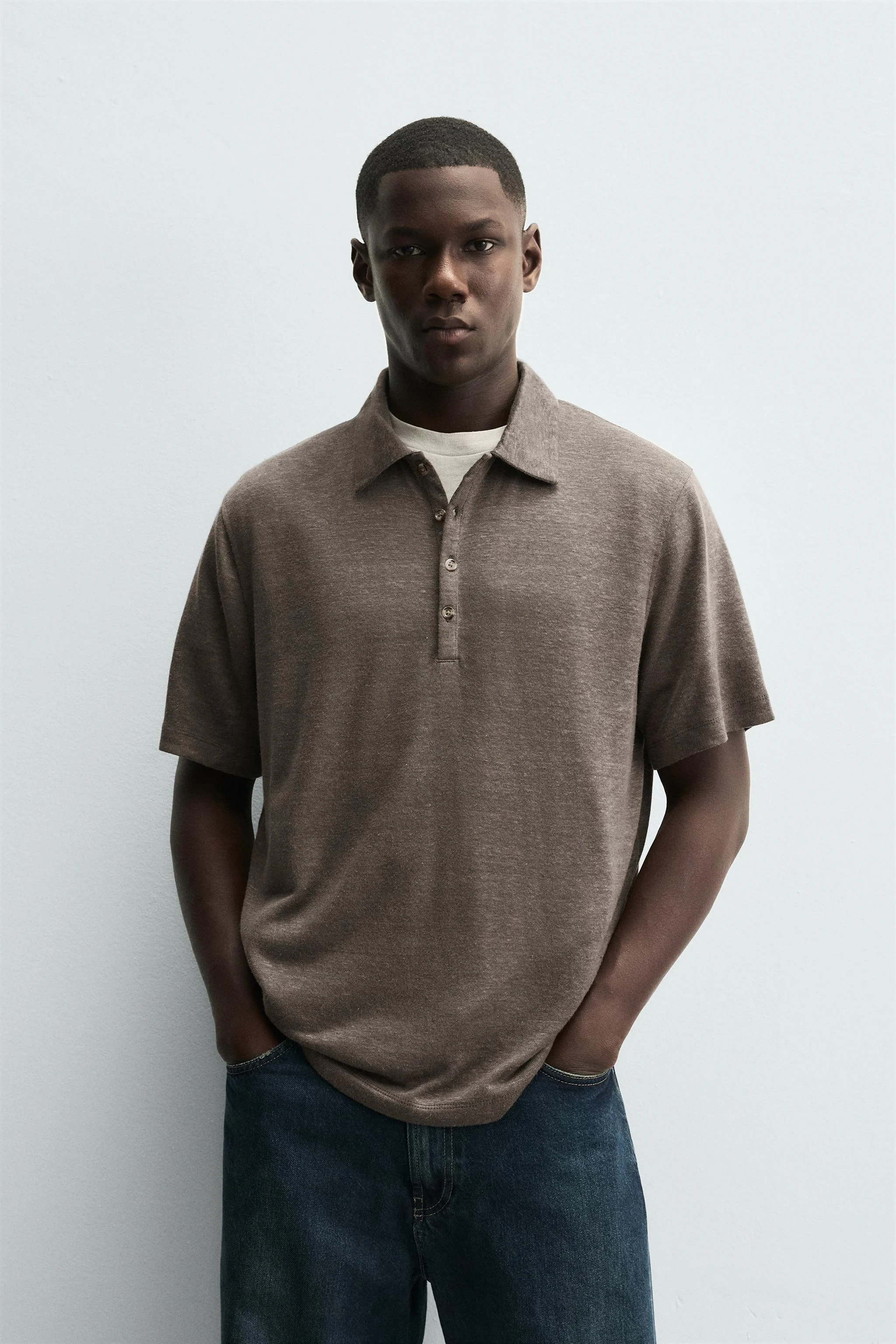 پولوشرت با فیت آزاد، ساخته شده از ترکیب کنف و ویسکوز. دارای یقه برگردان با بست دکمه‌ای در جلو و آستین کوتاه.