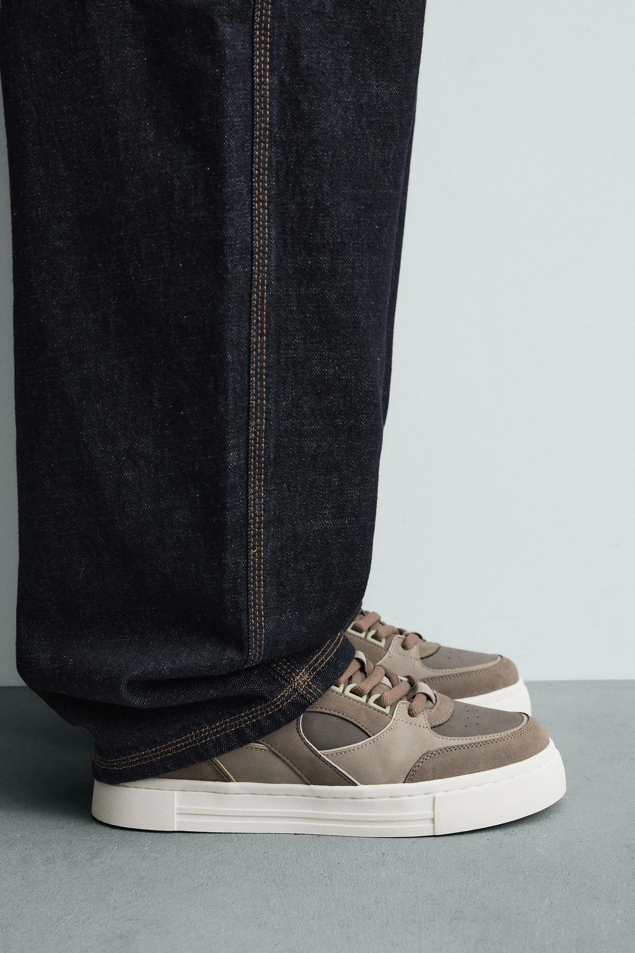 کفش ورزشی بند دار به سبک رترو. رویه ساخته شده از ترکیبی از قطعات مختلف. زیره ضخیم.