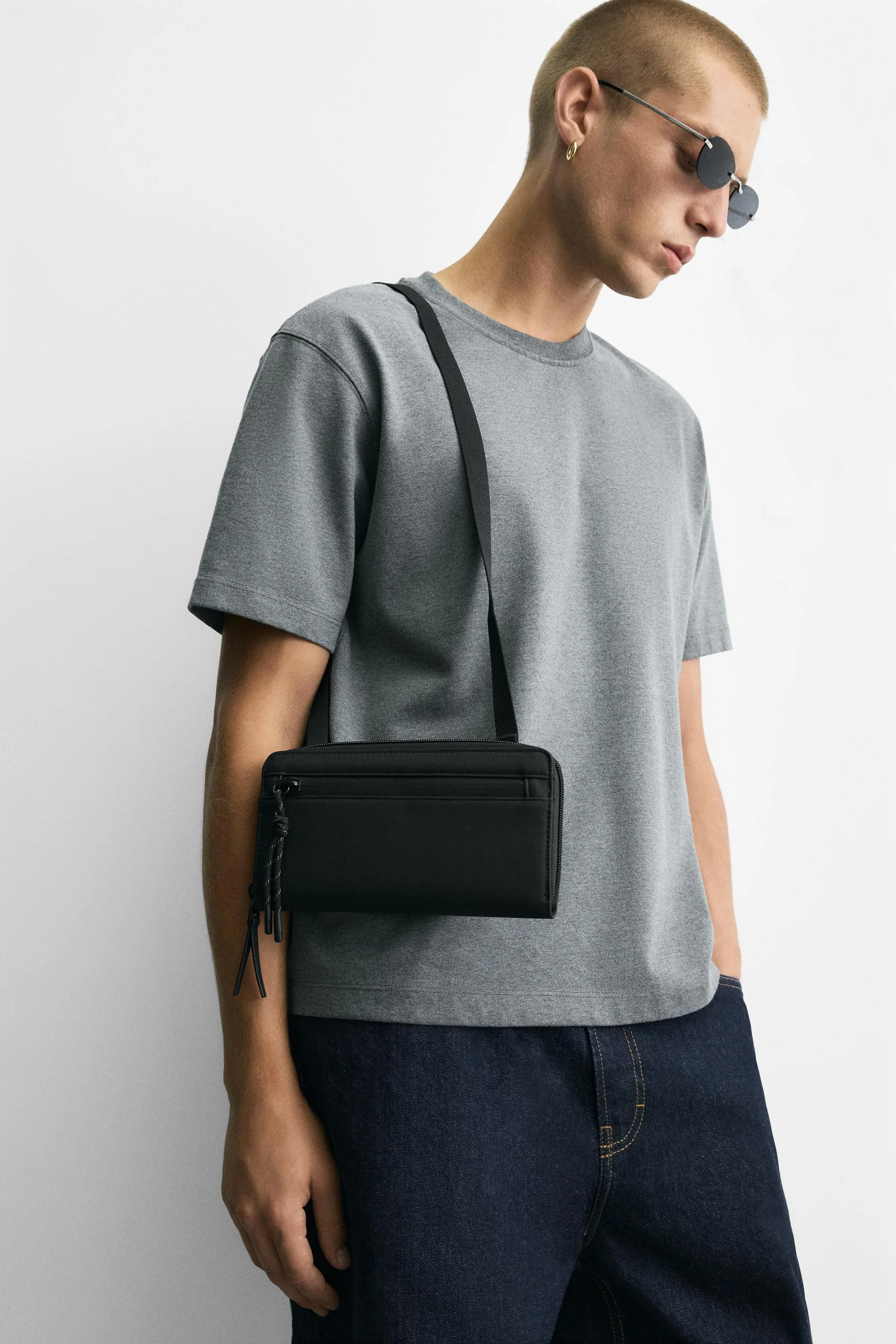 کیف دوشی با روکش لاستیکی. محفظه اصلی با بست زیپی. قسمت داخلی دارای یک جیب با بست زیپی. بند شانه قابل تنظیم و جدا شدن. ارتفاع x طول x عرض: 12 x 22 x 2.5 سانتی متر.