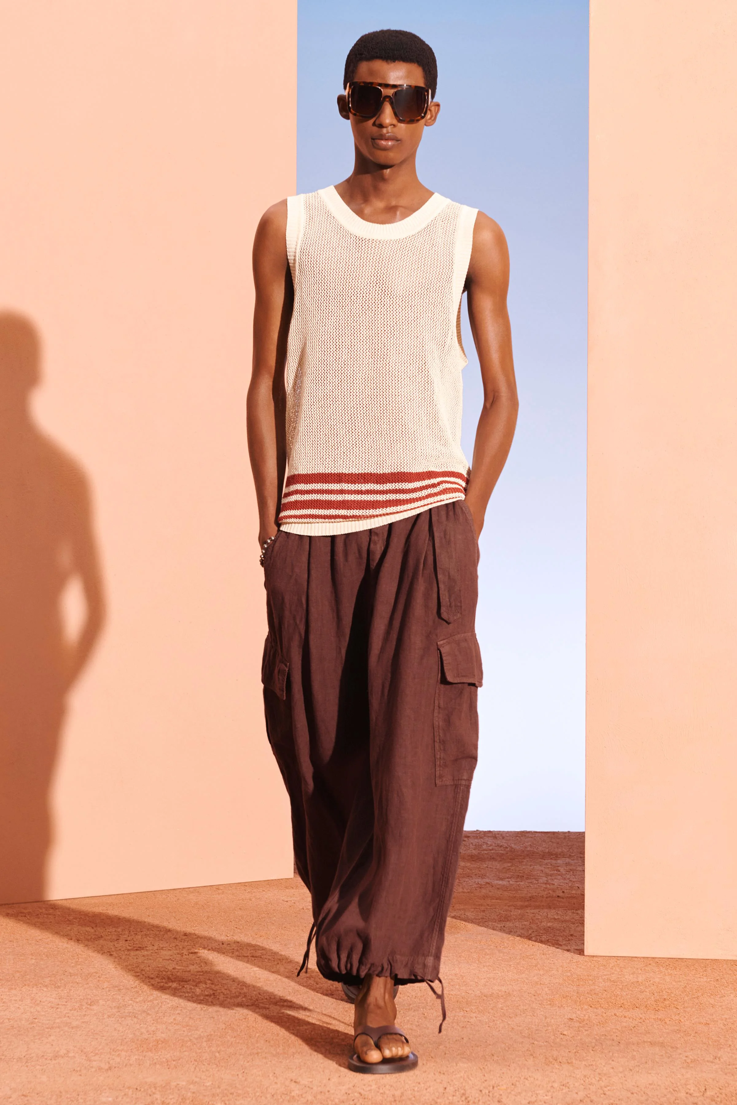 تاپ رکابی با بافت باز، ترکیبی از کتان و پنبه. دارای یقه گرد پهن و طراحی بدون آستین. لبه های کشباف.