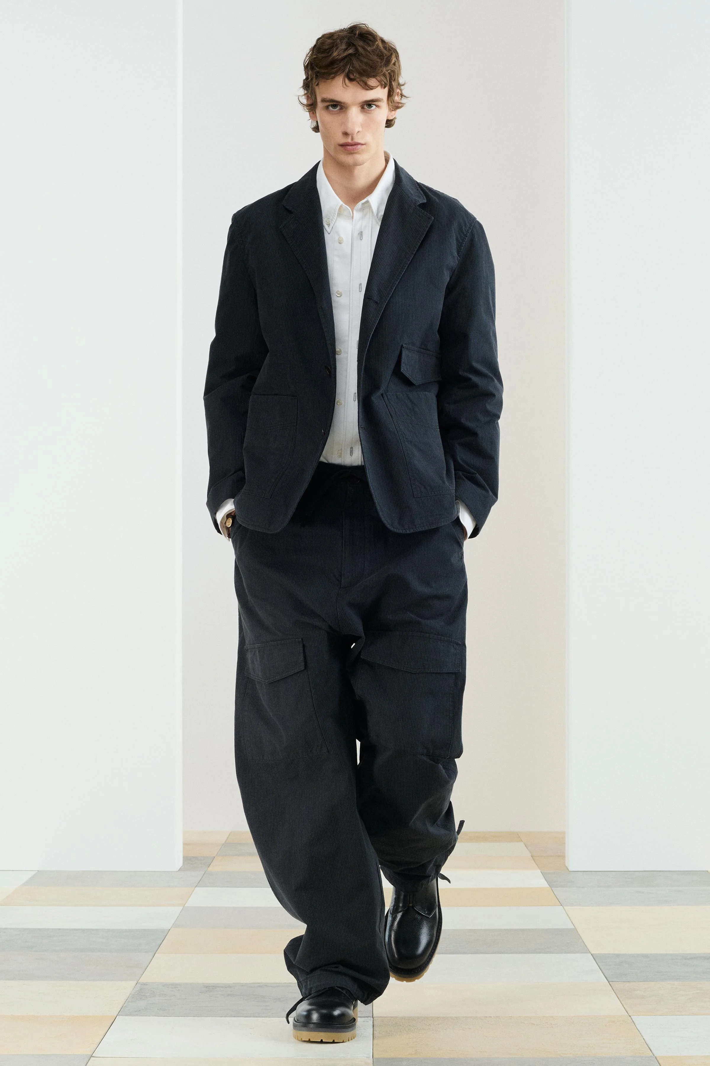 شلوار پارچه‌ای با فیت آزاد. دارای کمر کشی با بند قابل تنظیم، جیب‌های جلو و جیب‌های پشتی وصله‌ای با سرپوش. جیب‌های وصله‌ای با سرپوش روی پاها. لبه قابل تنظیم با بندهای کناری. دارای زیپ و دکمه.