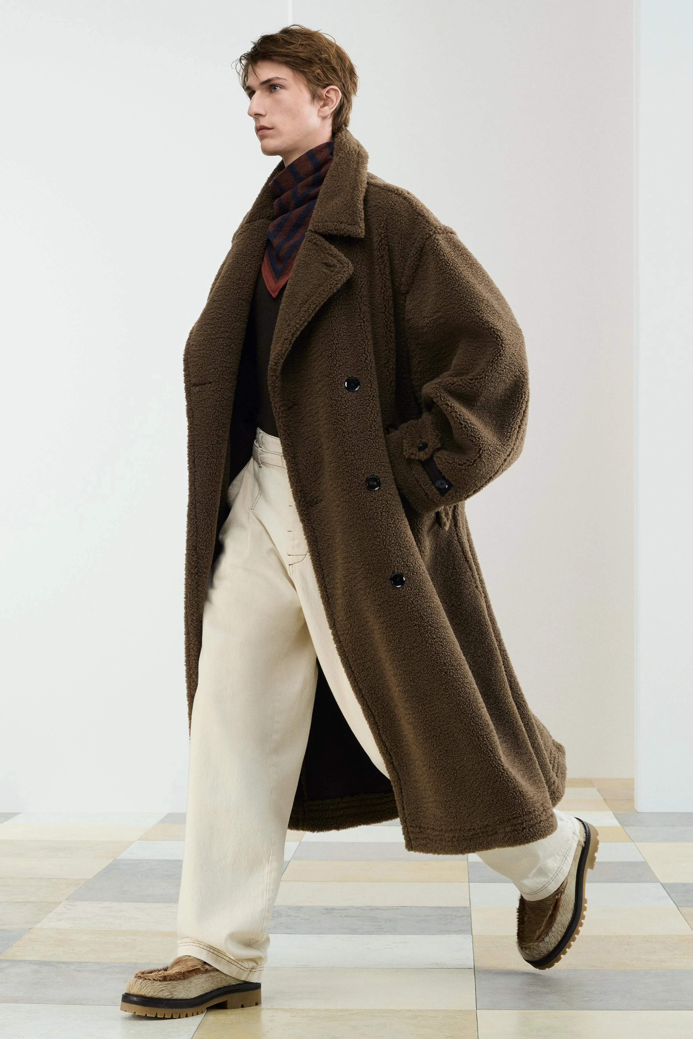 بارانی مدل TDY TRNCH با تن خور راحت، تهیه شده از پارچه جیر مصنوعی به همراه خز مصنوعی. دارای یقه برگردان و آستین های بلند با سرآستین های قابل تنظیم. شامل جیب های پاکتی روی باسن و یک چاک در قسمت پشتی پایین. با دکمه دوبل در جلو بسته می شود.