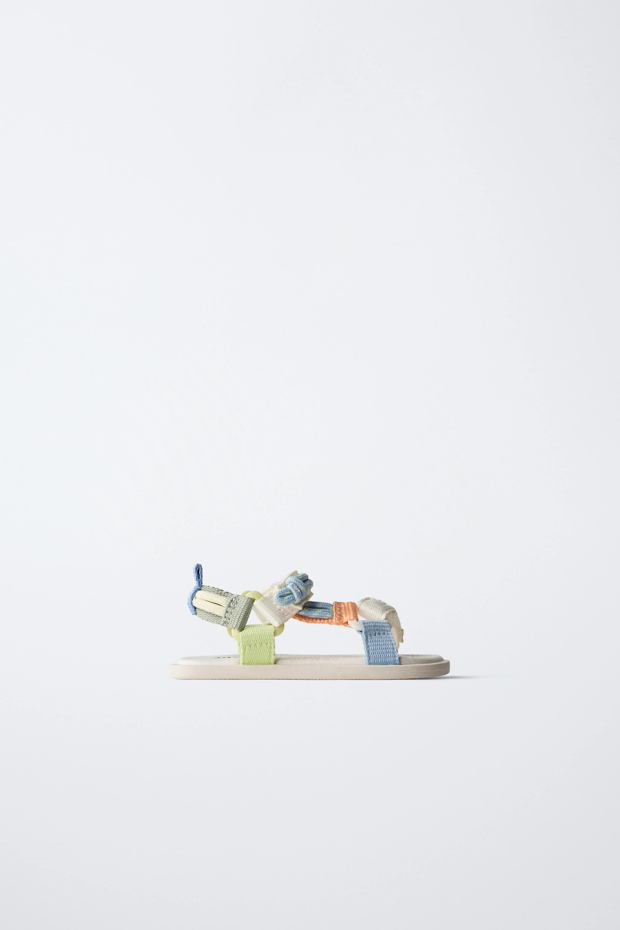 صندل های فنی پا برهنه با جزئیات طناب رنگی متضاد. دارای بندهای چسبی در قسمت روی پا. زیره لاستیکی انعطاف پذیر با شیب مناسب و پاشنه بسیار منعطف.