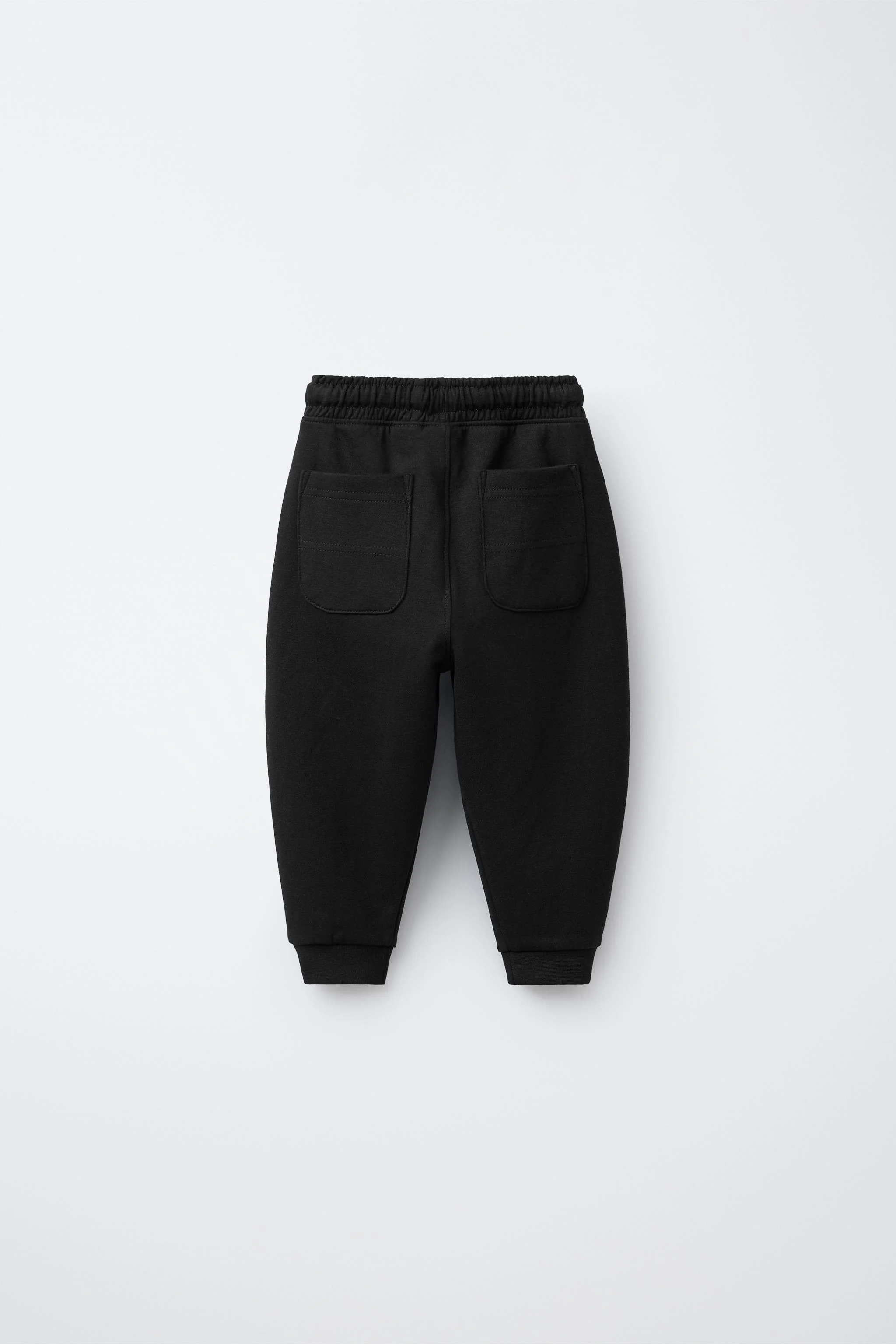 شلوار جاگر بافتنی با کمر کشی و بند قابل تنظیم. دارای جیب های جلویی با زیپ حرارتی و جیب های پشتی. ساخته شده از 87% پنبه.