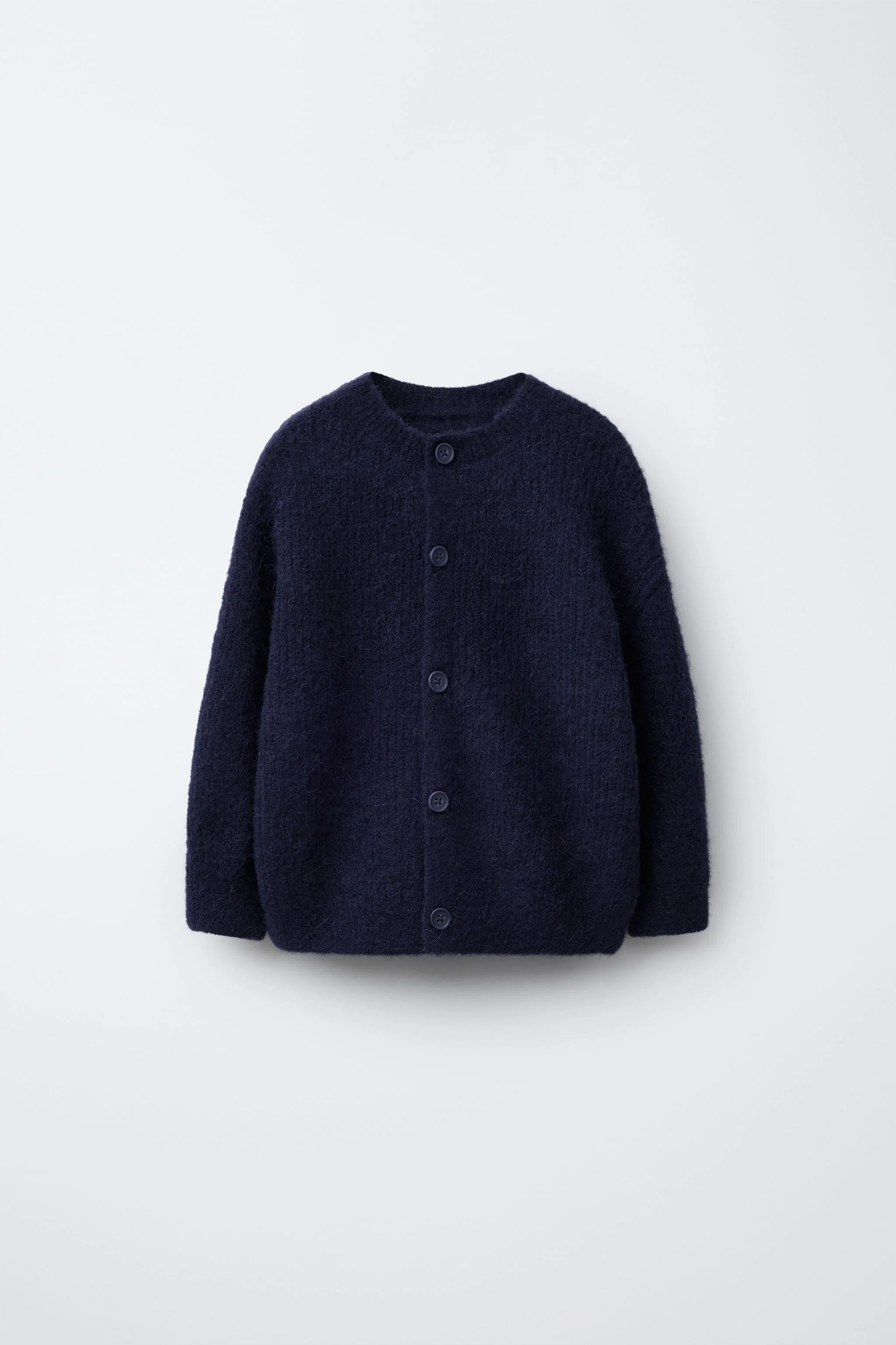 کاردیگان بافتنی با یقه گرد و آستین بلند. دارای دکمه در جلو. تهیه شده از 13% پشم و 12% آلپاکا.