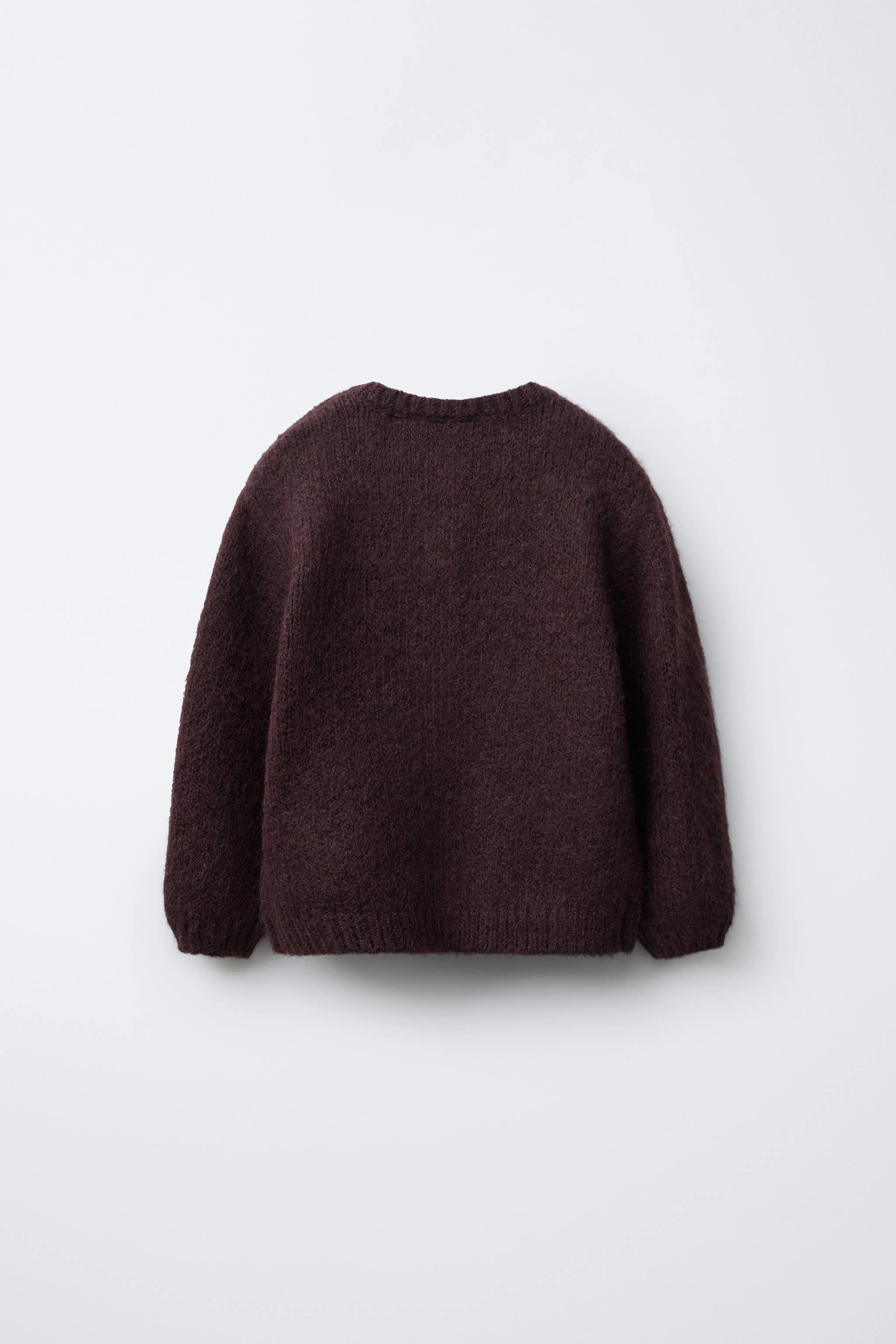 ژاکت کشباف با یقه گرد و آستین بلند. دارای دکمه در قسمت جلو.