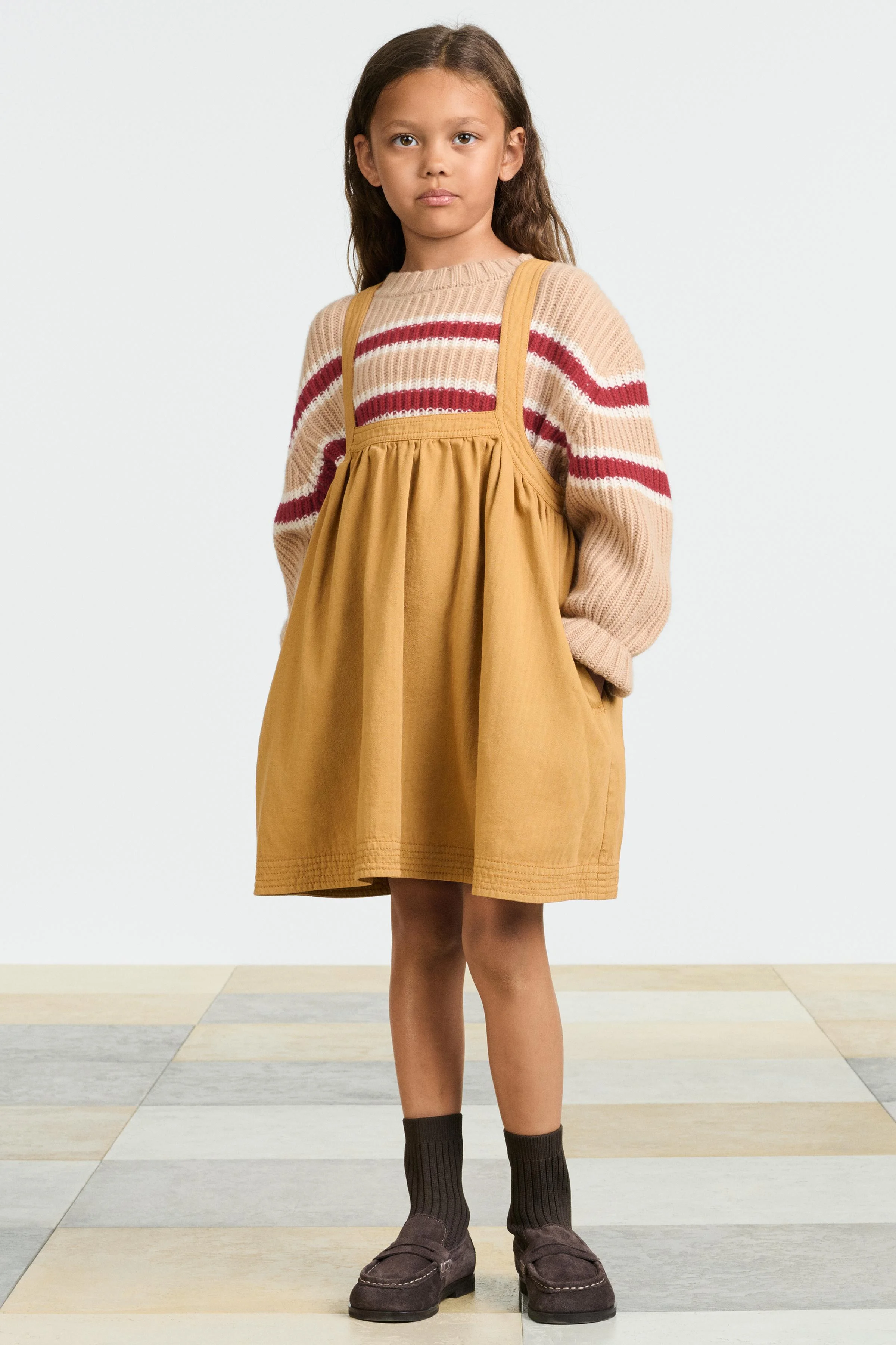 پیراهن پیشبندی با یقه گرد و بندهای ضربدری در پشت. دارای جزئیات دکمه. جیب های جانبی مخفی در درز. پارچه 100% پنبه.