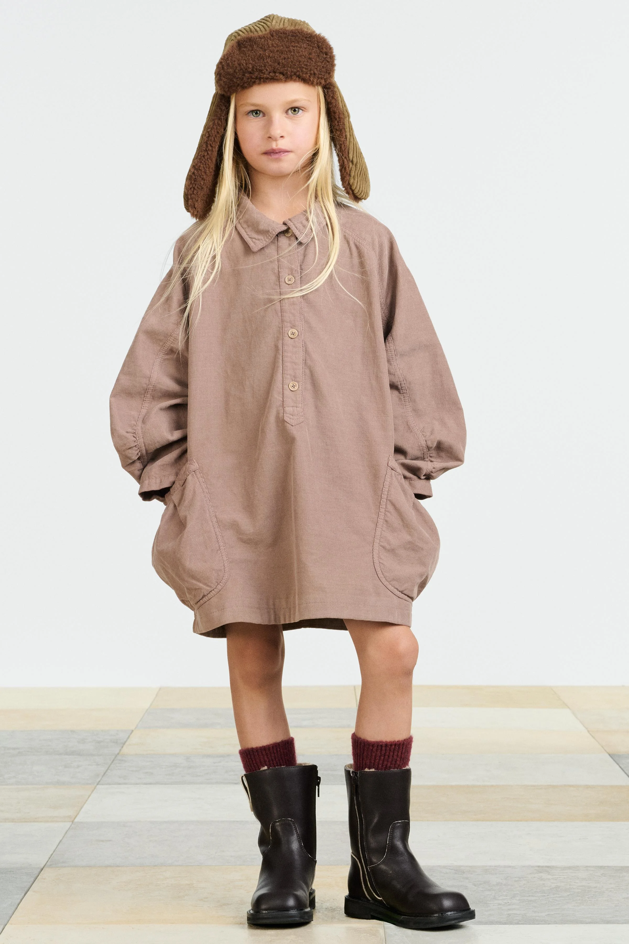 پیراهن کبریتی با یقه پیراهن مردانه و آستین های پفی بلند. دارای دکمه در قسمت جلویی و جیب های وصله ای در طرفین.