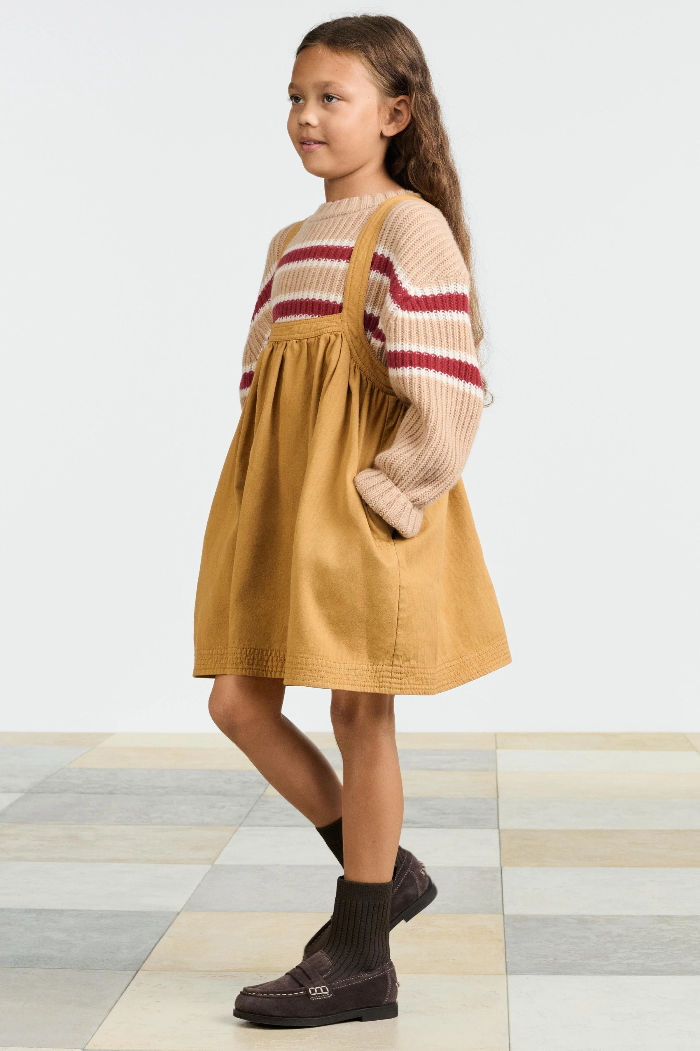 پیراهن پیشبندی با یقه گرد و بندهای ضربدری در پشت. دارای جزئیات دکمه. جیب های جانبی مخفی در درز. پارچه 100% پنبه.