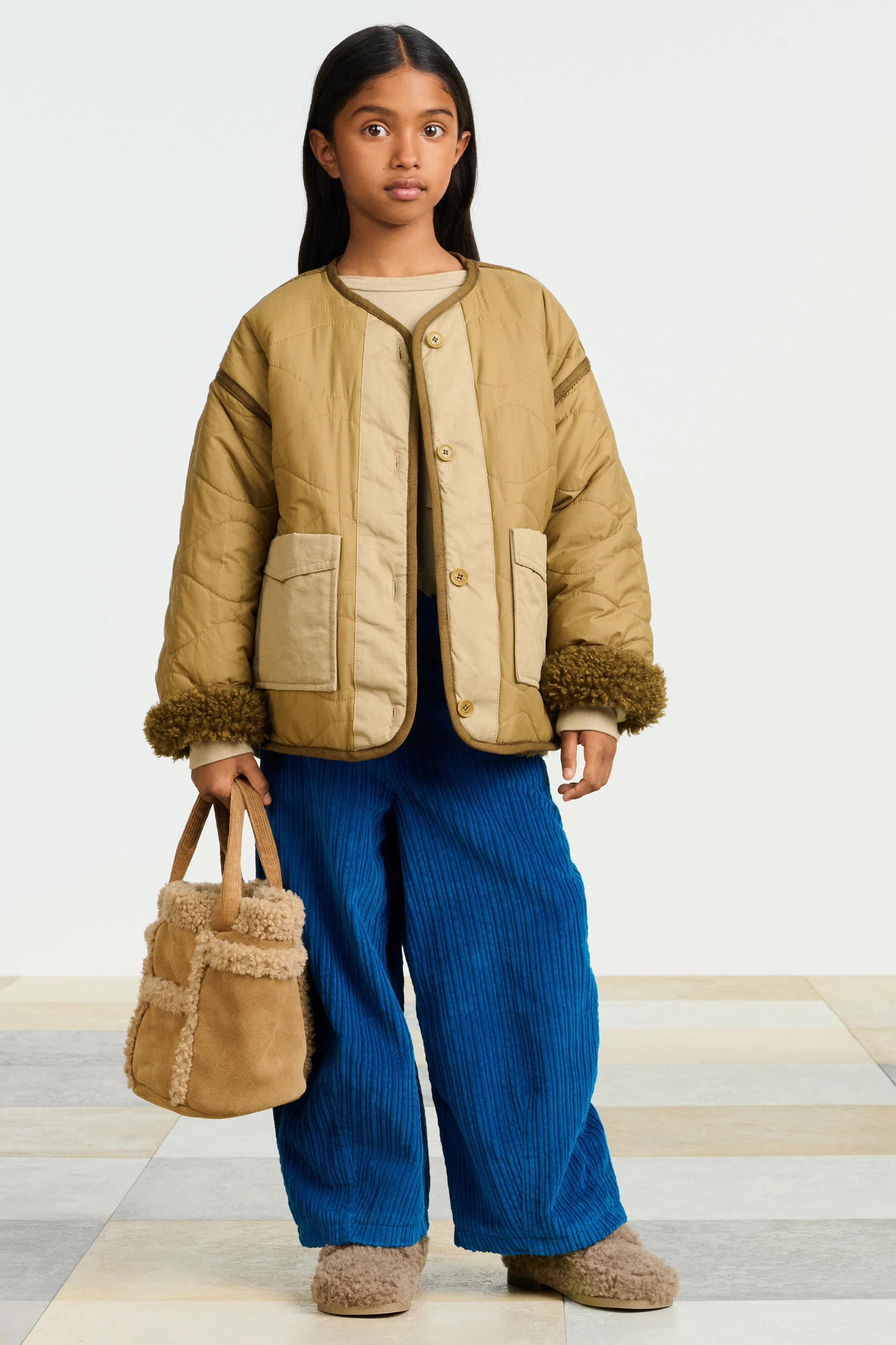 ژاکت دو رو با طرح لحافی، یقه گرد و آستین بلند با سرآستین های تاشو. دارای دکمه در جلو. جیب های تکه ای در جلو. دارای جزئیات داخلی پشم مصنوعی و جیب های جلویی با سرجیب های تزئینی.