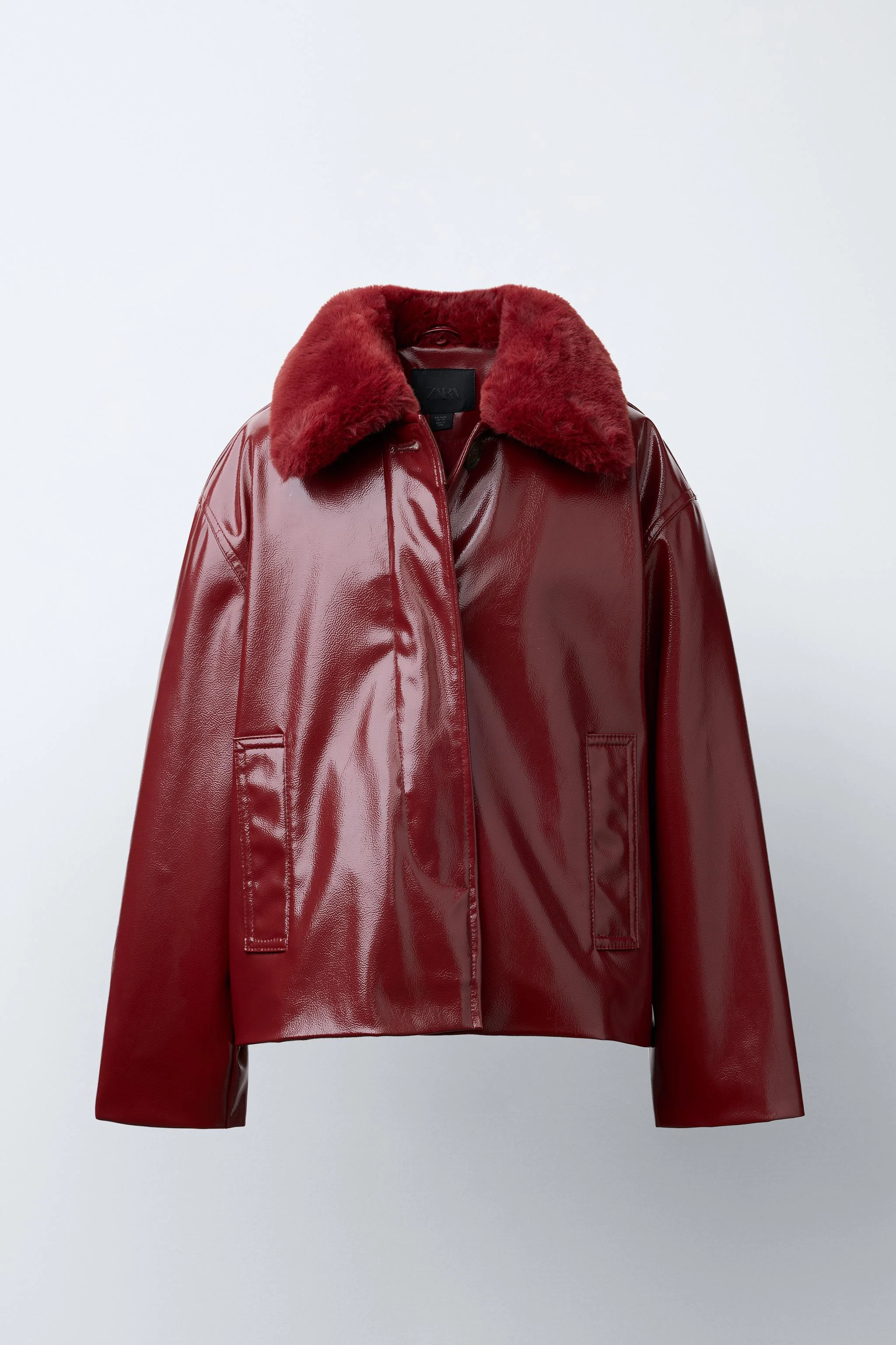 کت آستین بلند با یقه خز مصنوعی که با دکمه جدا می شود. دارای بست دکمه ای جلویی مخفی و جیب های جلویی با جزئیات سجاف.